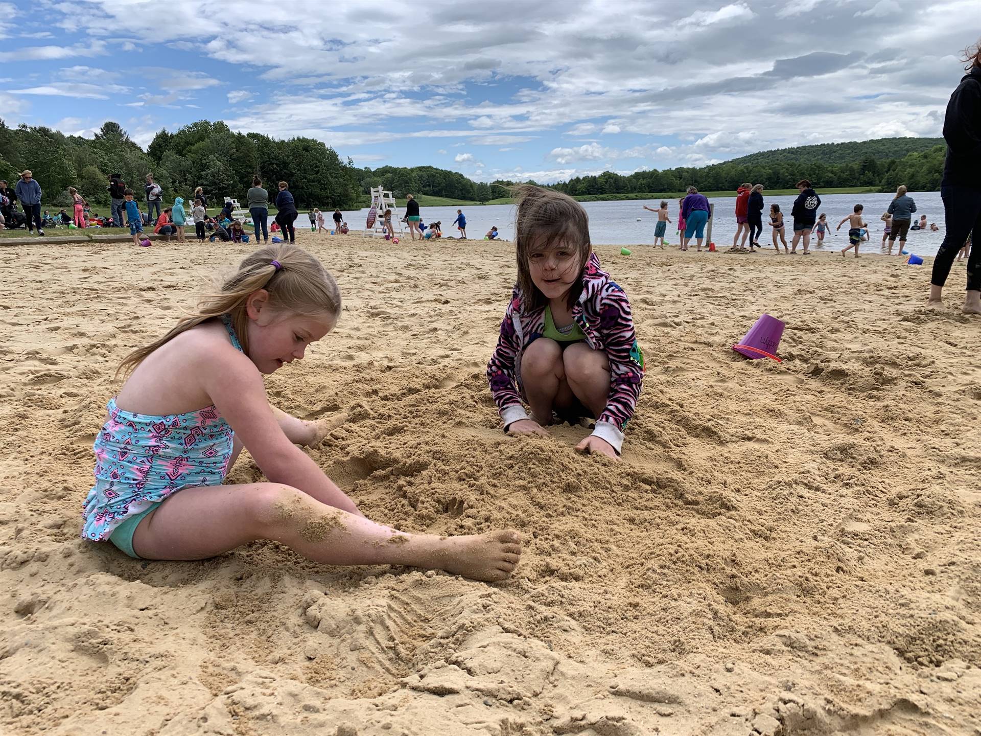 2 students play in sand.