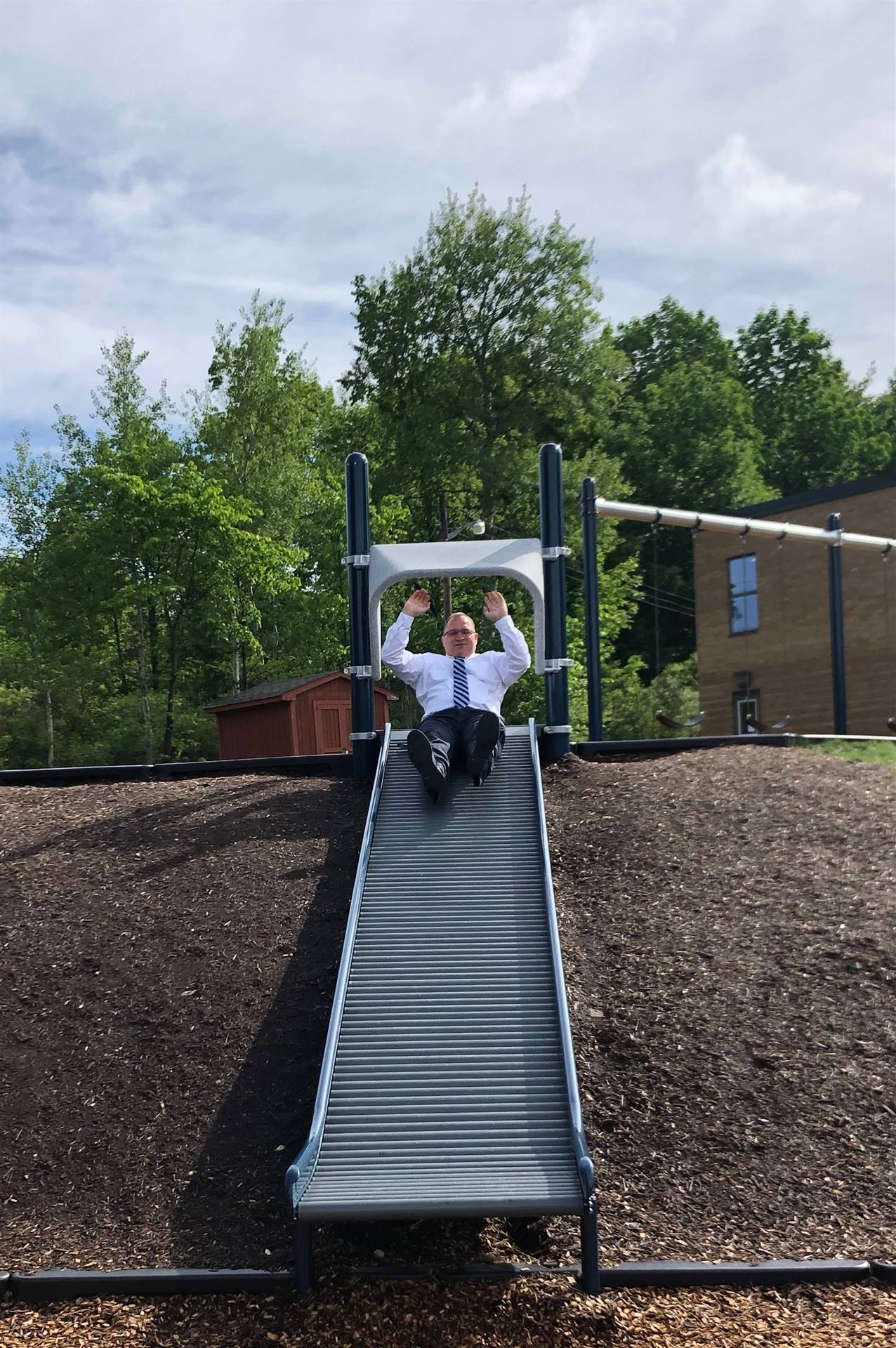 Adult sliding down slide.