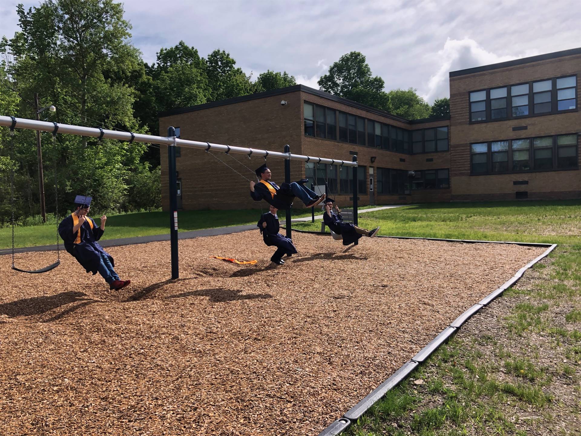 3 high school students swinging.