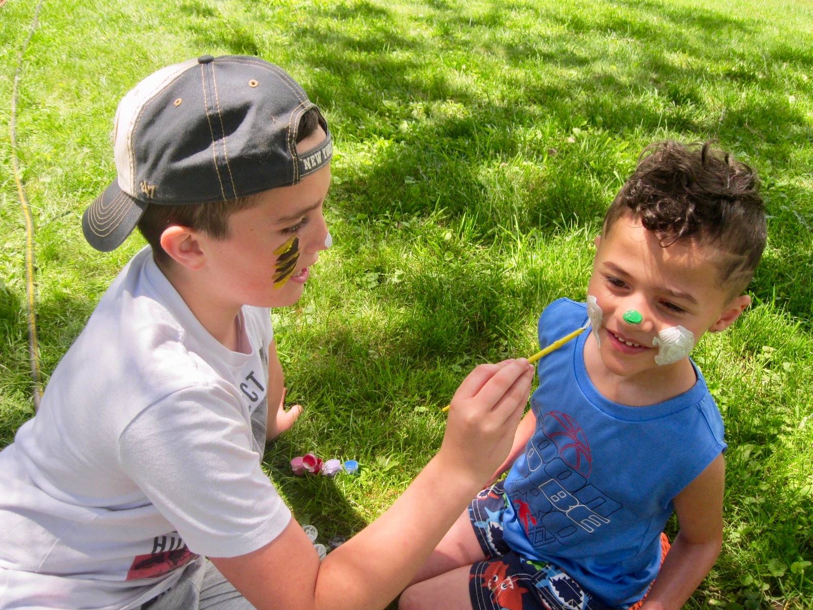 A student paints another student's face