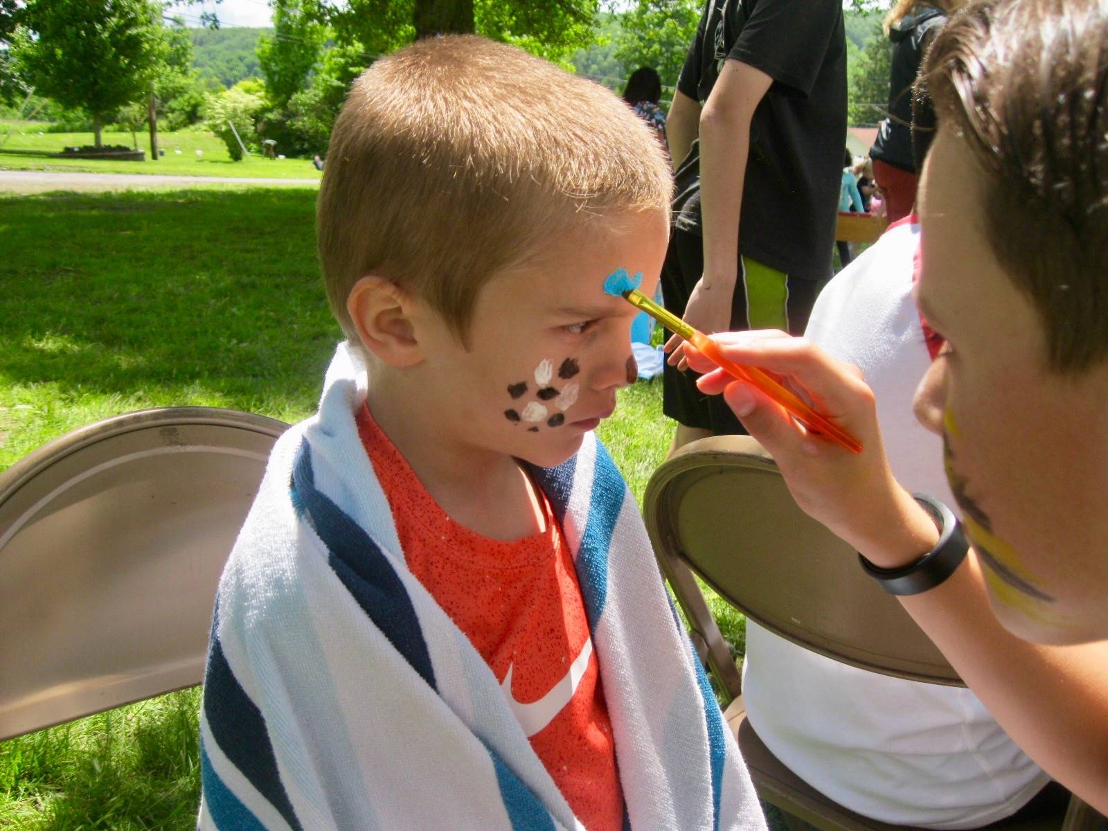 A student paints another student's face