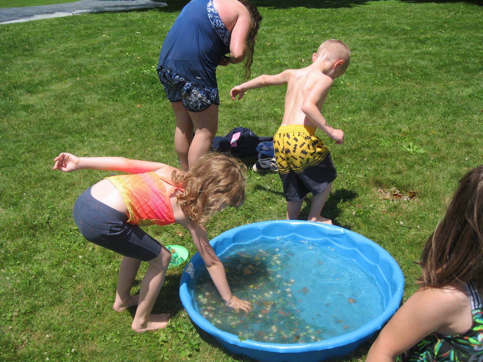 A student plucks out marbles from a wading pool.