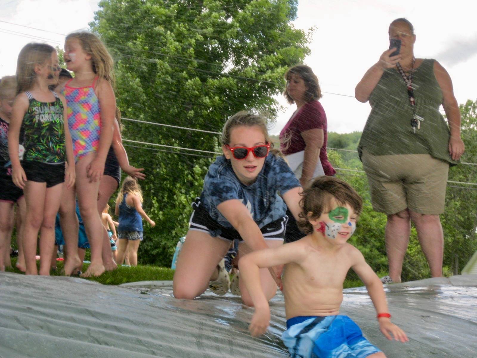 A student is pushed down water slide.