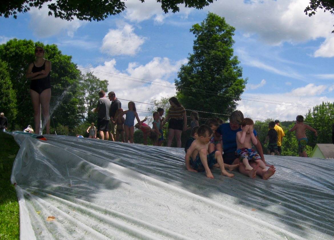 Students and aide on water slide.