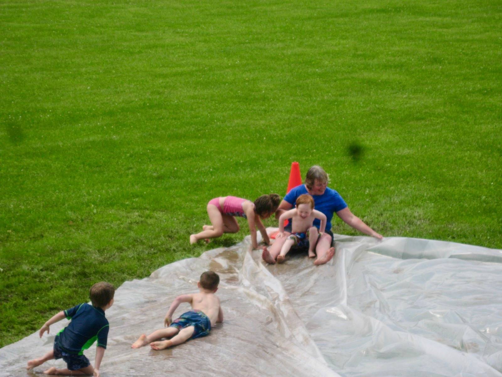 a group of student at bottom of water slide.