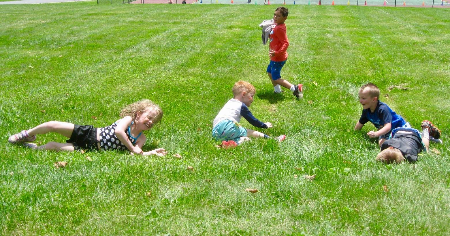 3 students roll down hill.