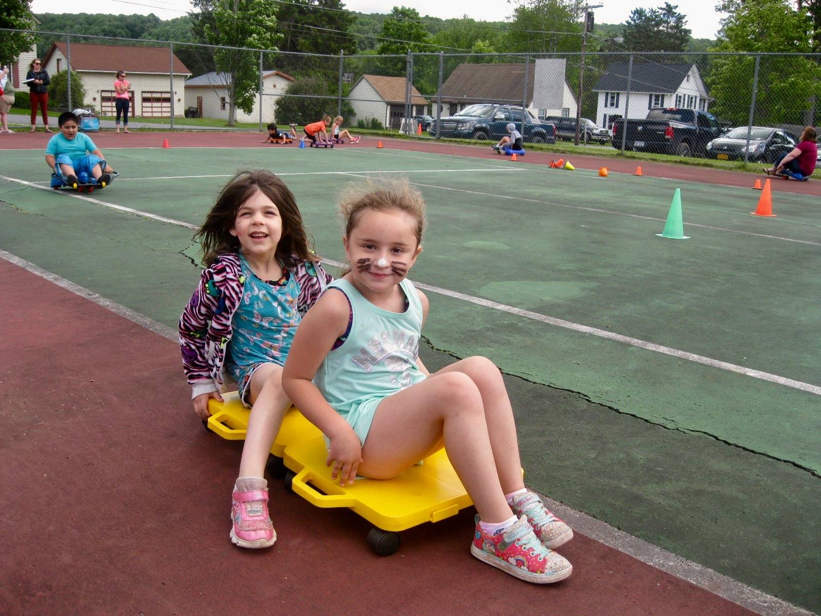 2 students ride a scooter.