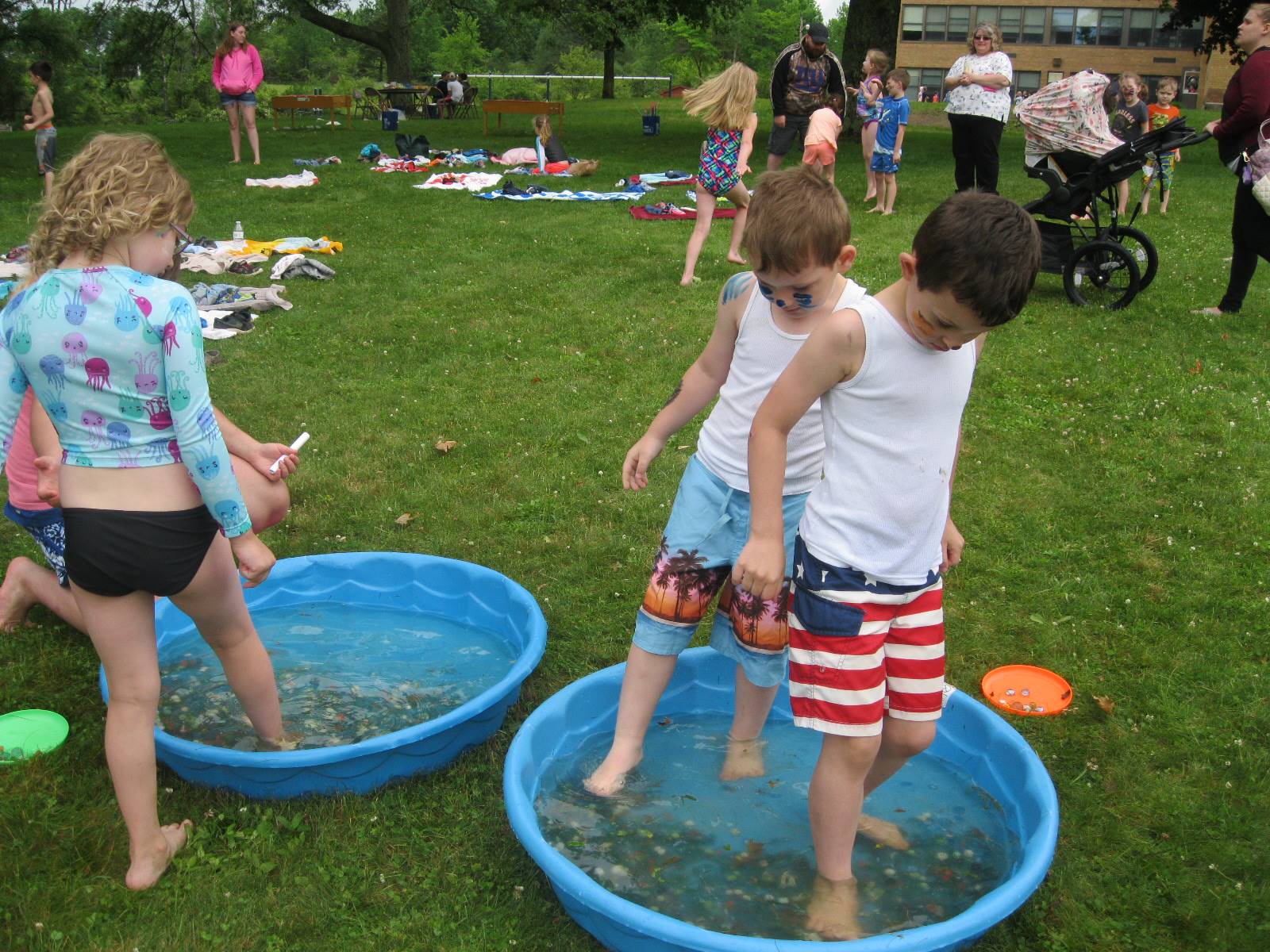 3 students using toes to get marbles.