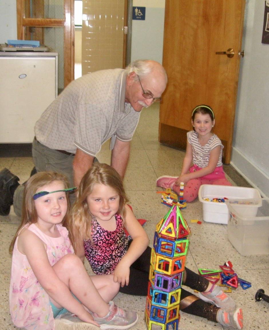 An adult volunteer plays with children
