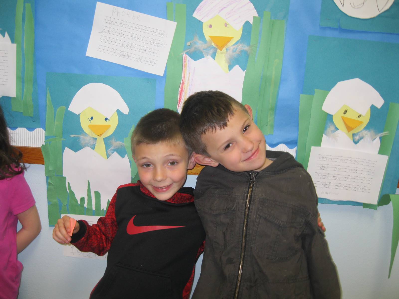 2 Students by their bulletin board of chicks.