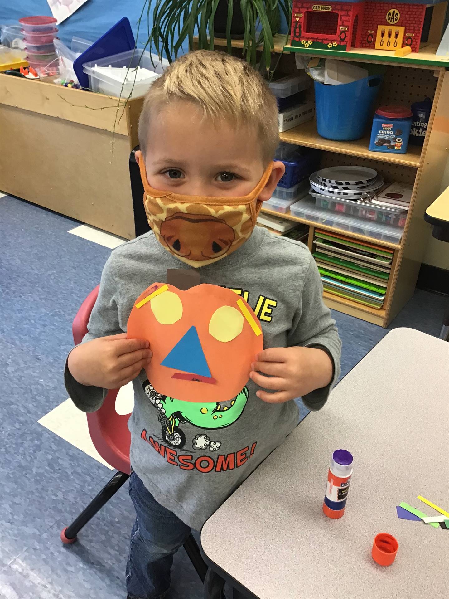 student holds up pumpkin and makes a matching emotion face.