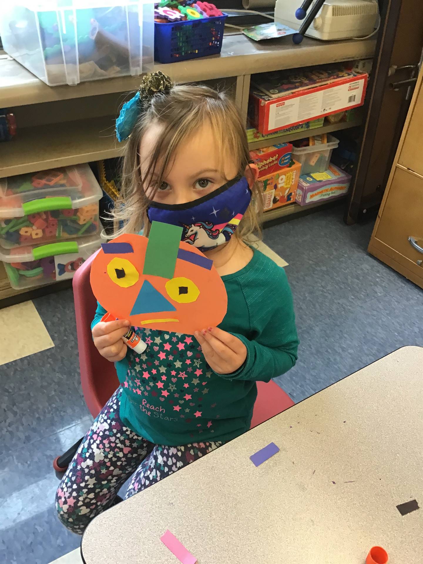 student holds up pumpkin and makes a matching emotion face.