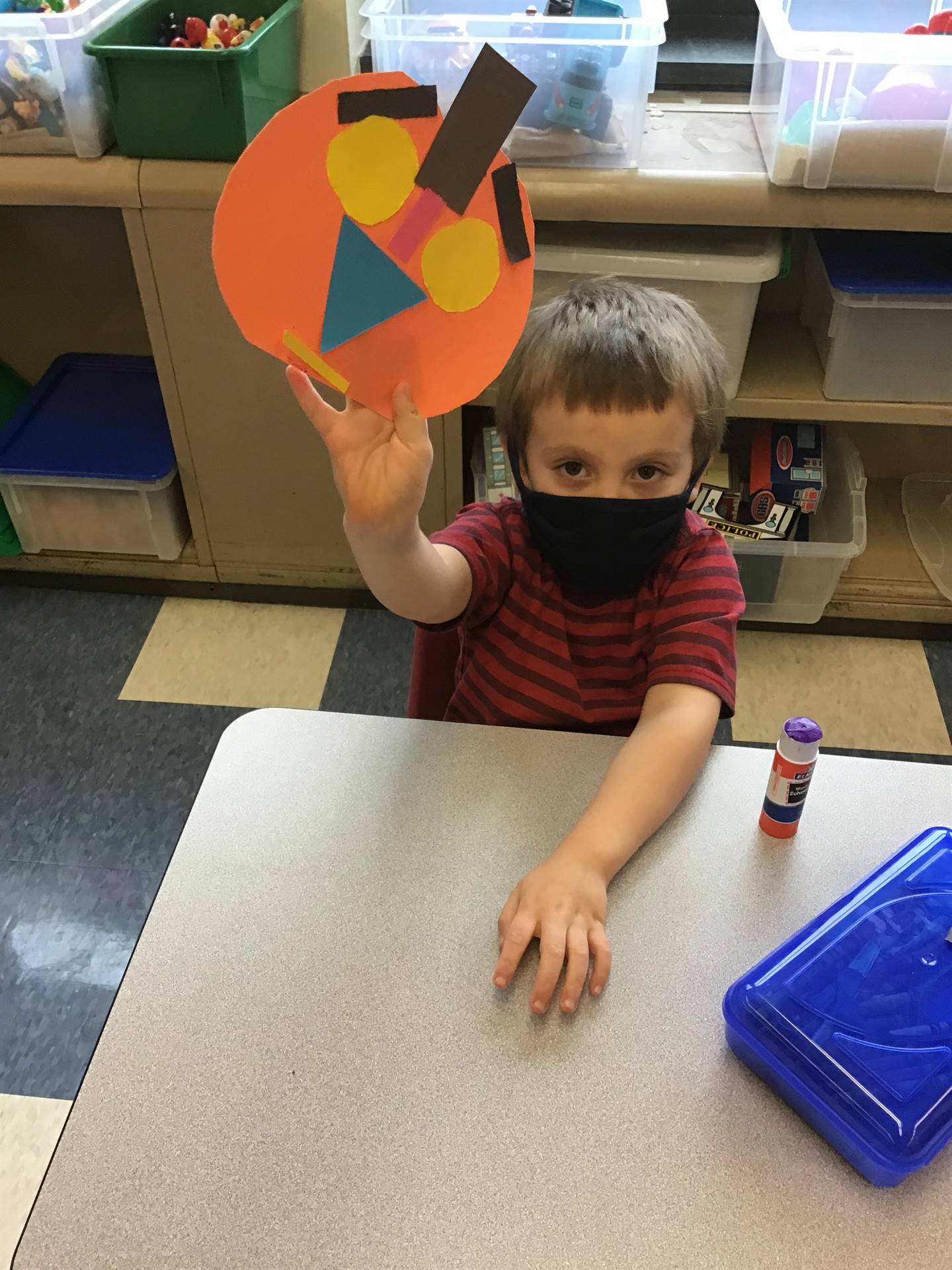 student holds up pumpkin and makes a matching emotion face.