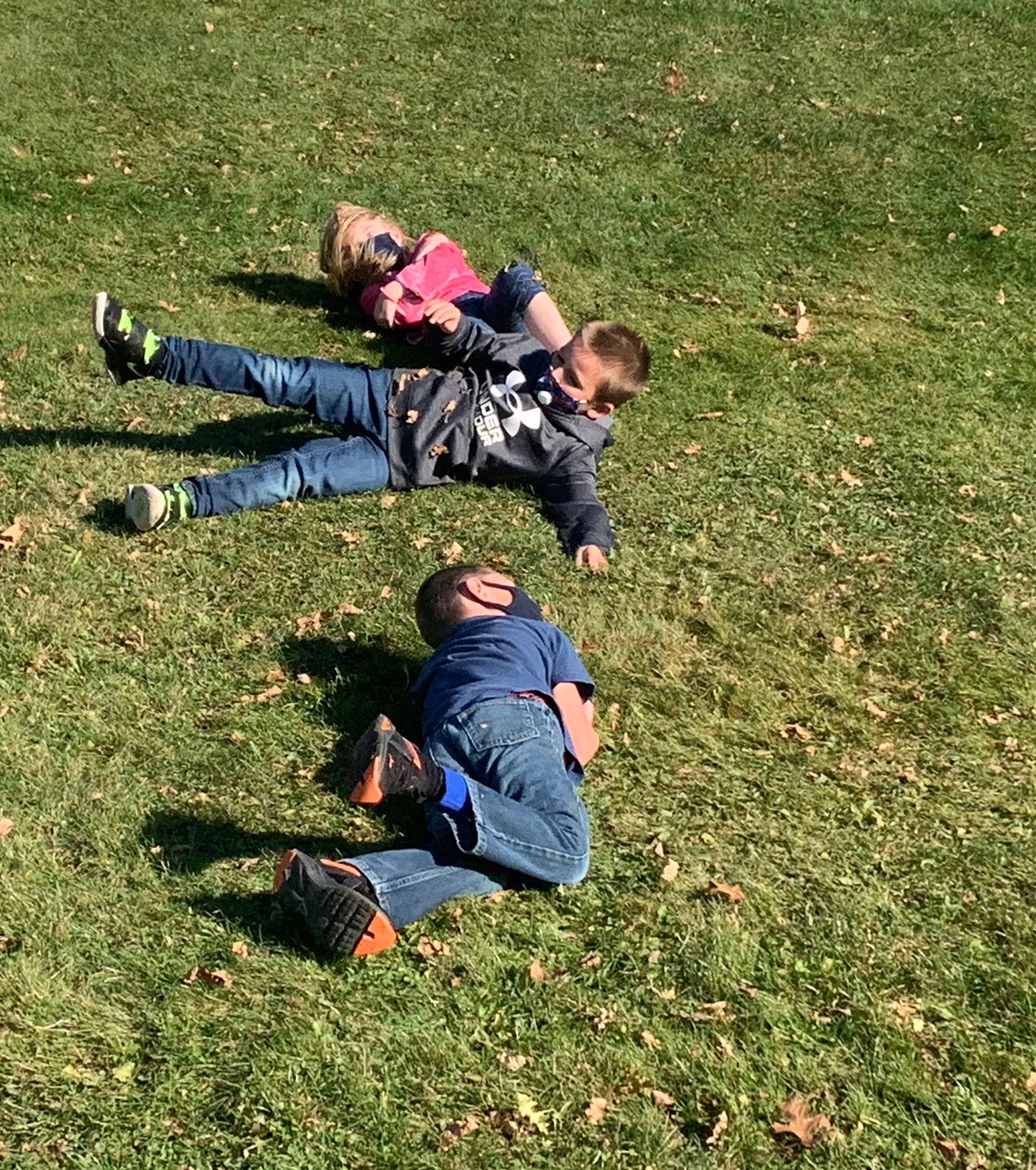 3 children roll down a hill