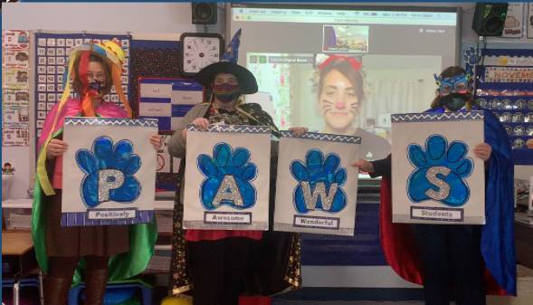 4 staff members dressed up with PAWS sign!