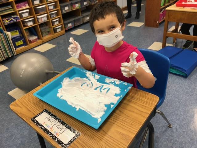 A student gives a thumbs up for shaving cream!