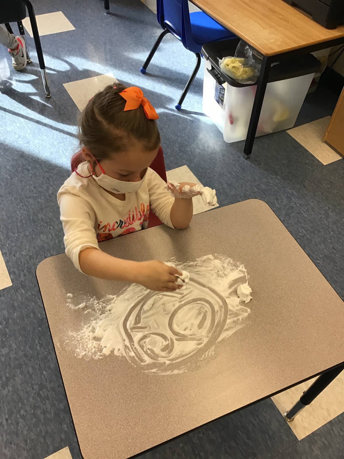 student draws a happy face  in shaving cream!