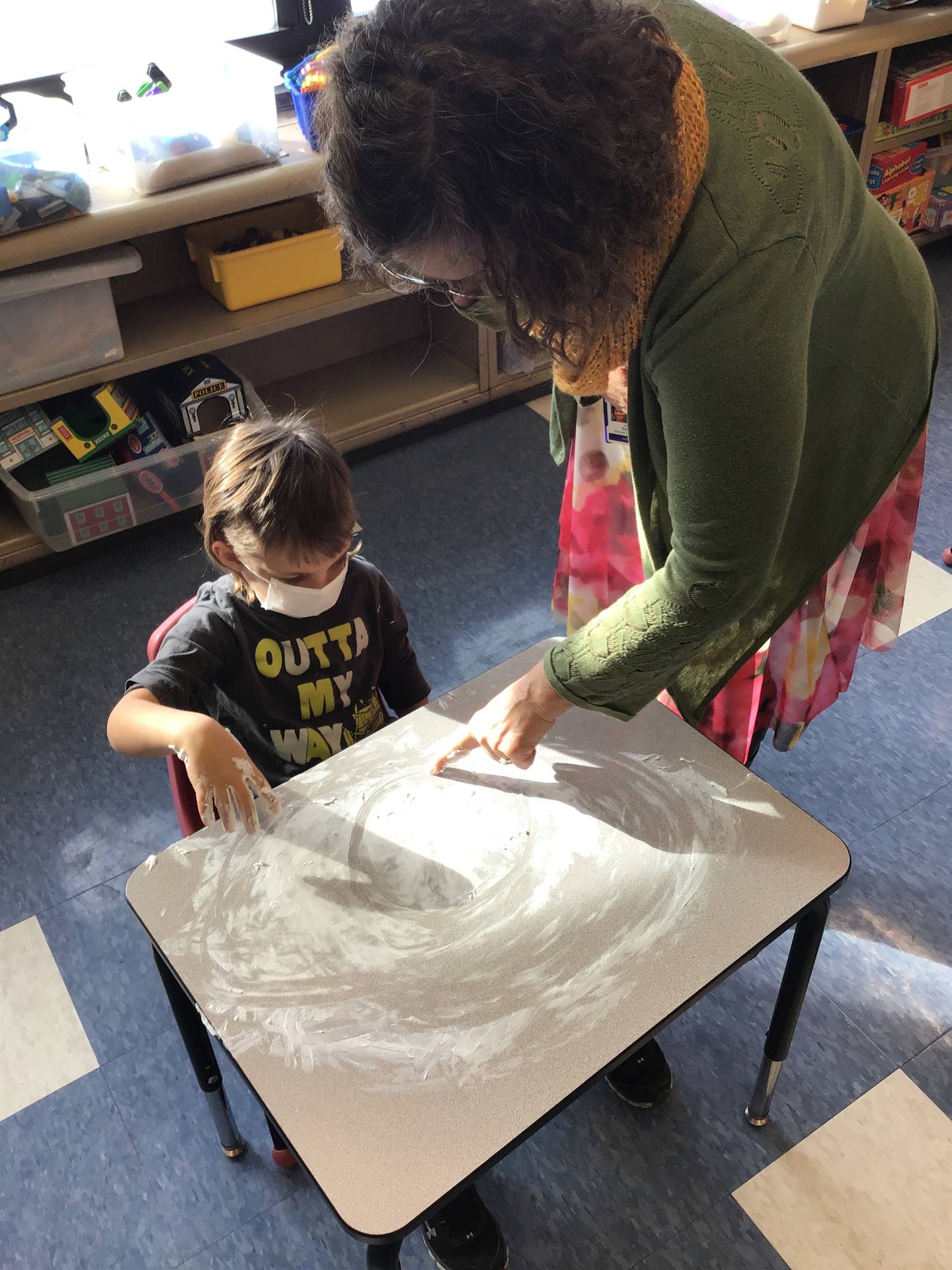 A staff member shows student how to draw a feeling.