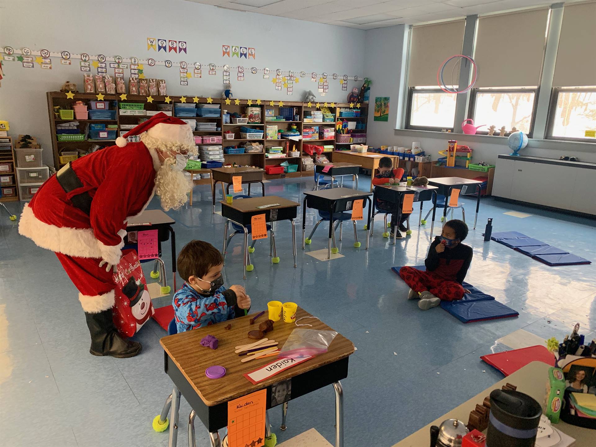 Santa looks at students in a classroom.