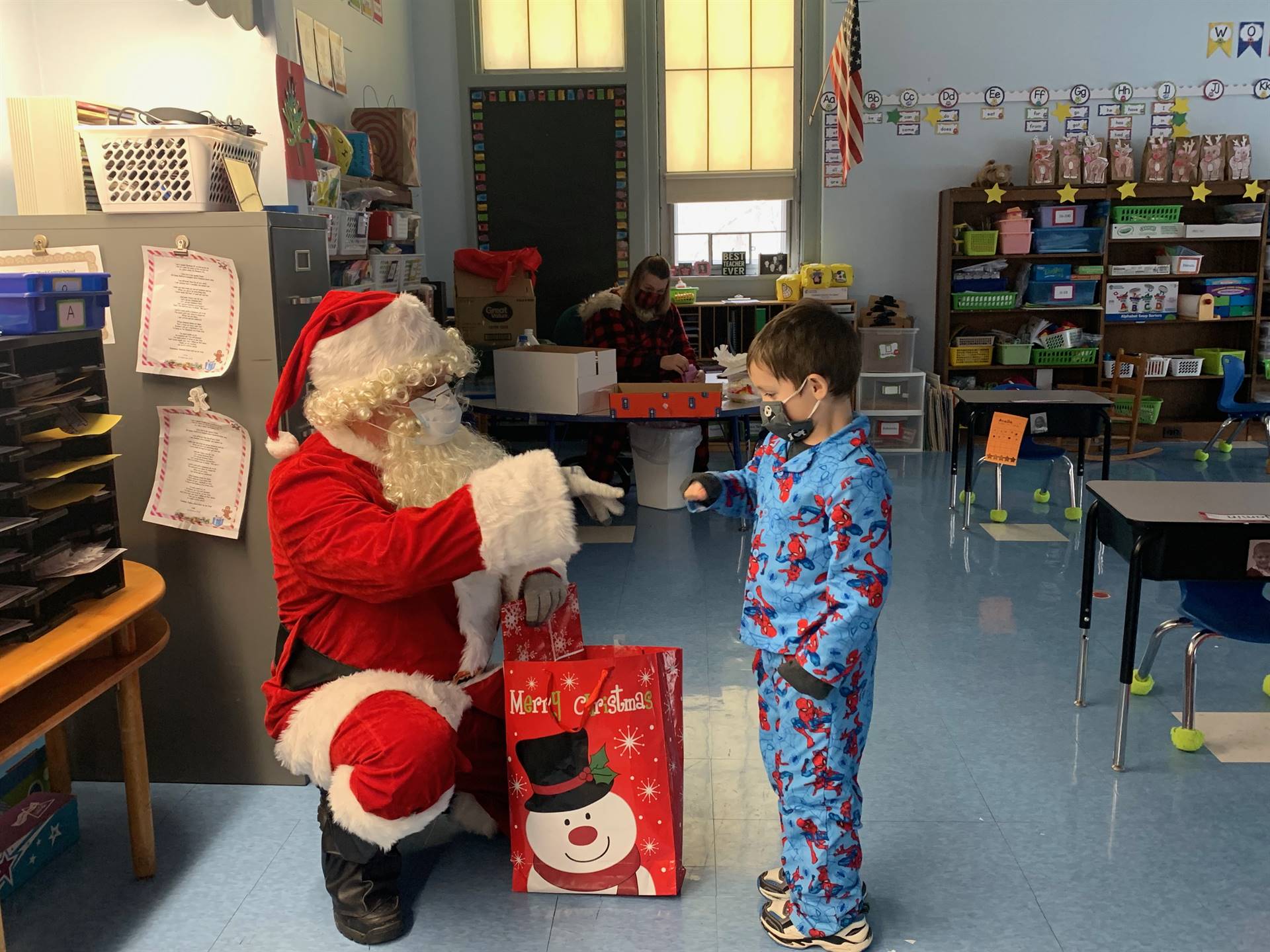 Santa hands a gift to a student.