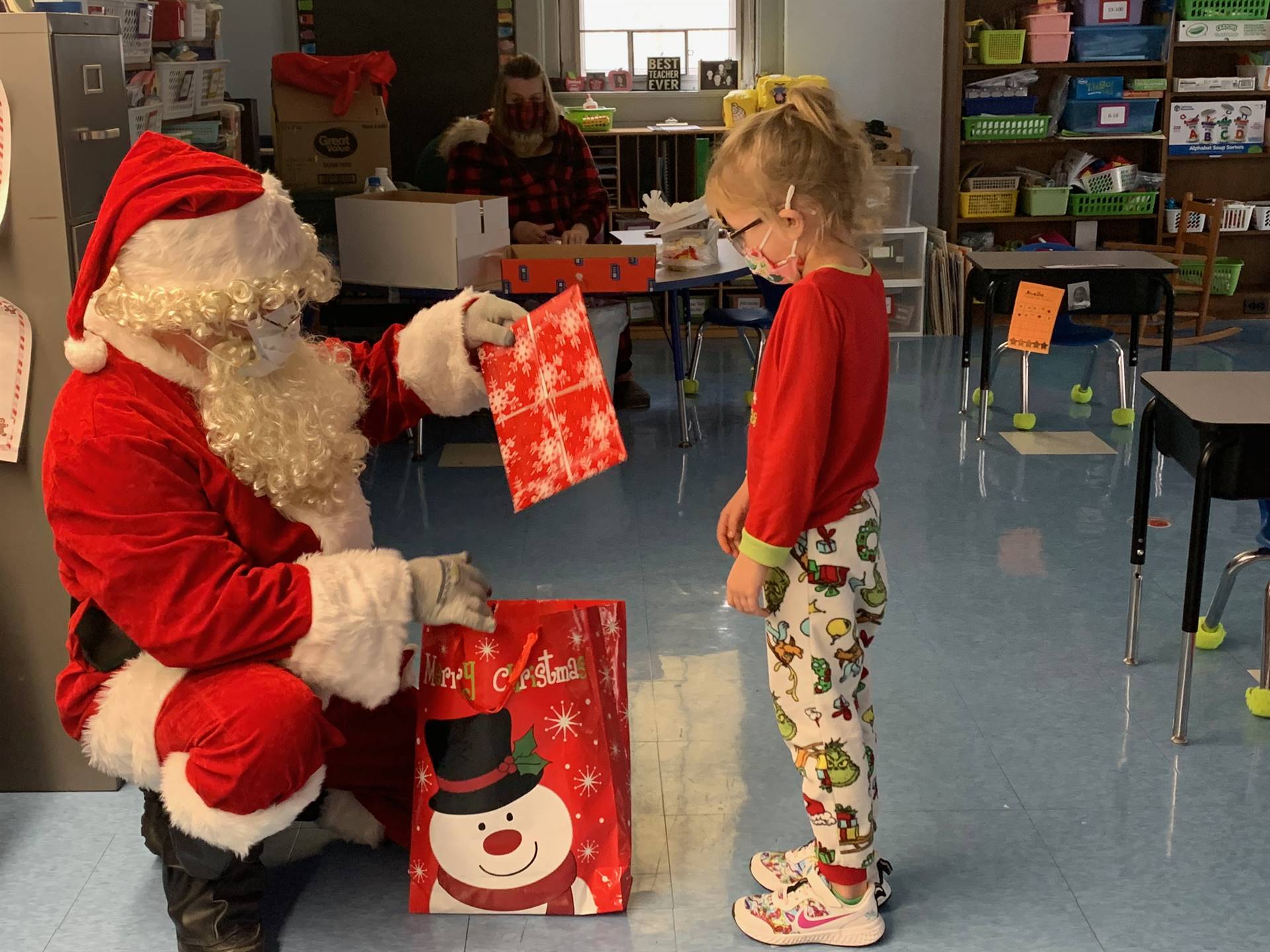 Santa giving a gift to a student.