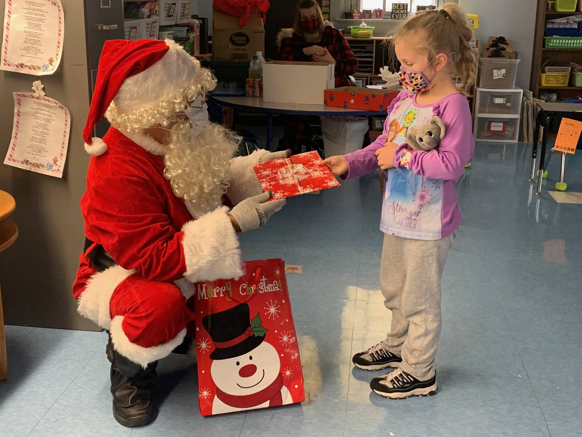 Santa gives gifts to a student.