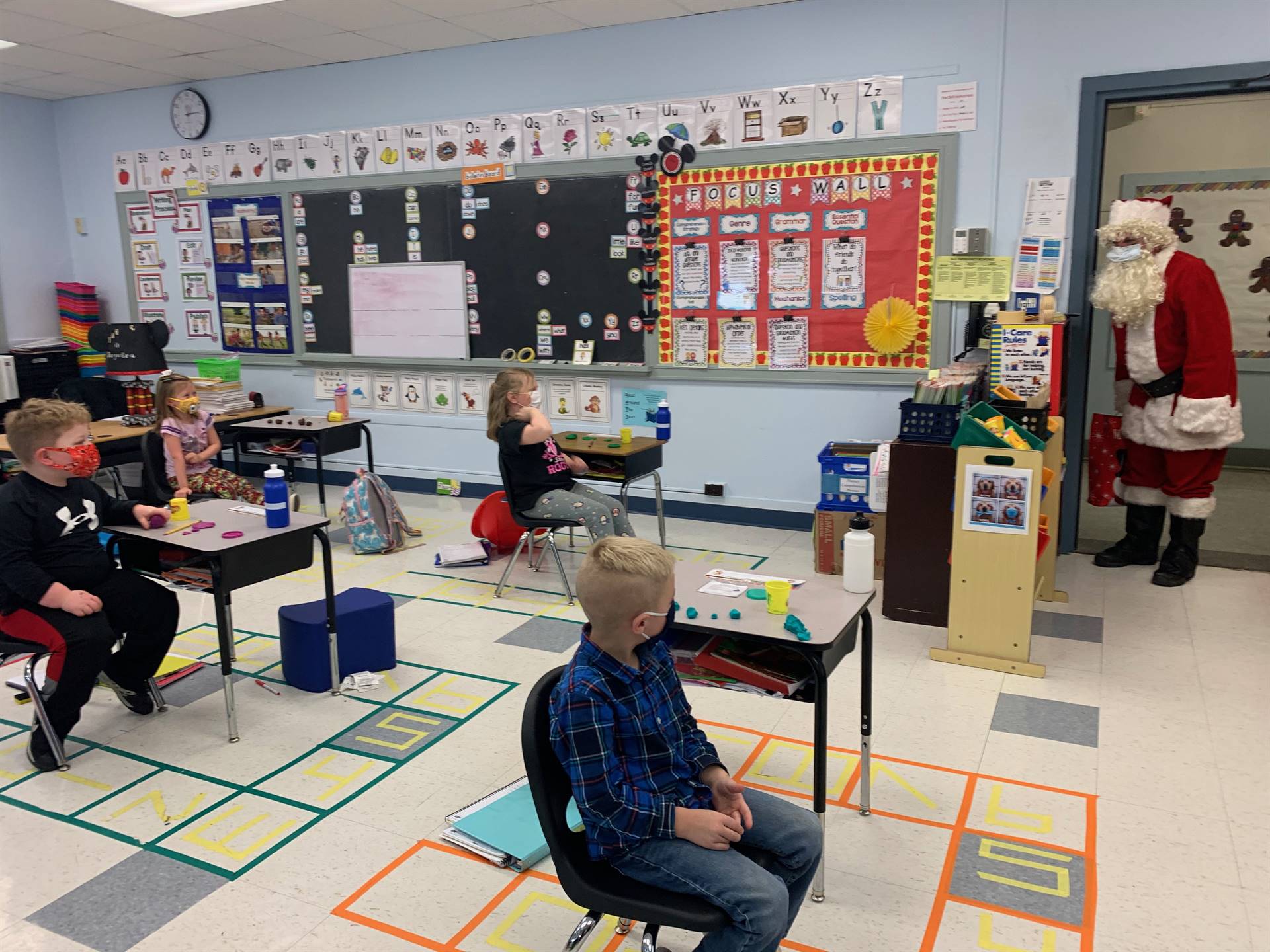 Santa enters a classroom. 