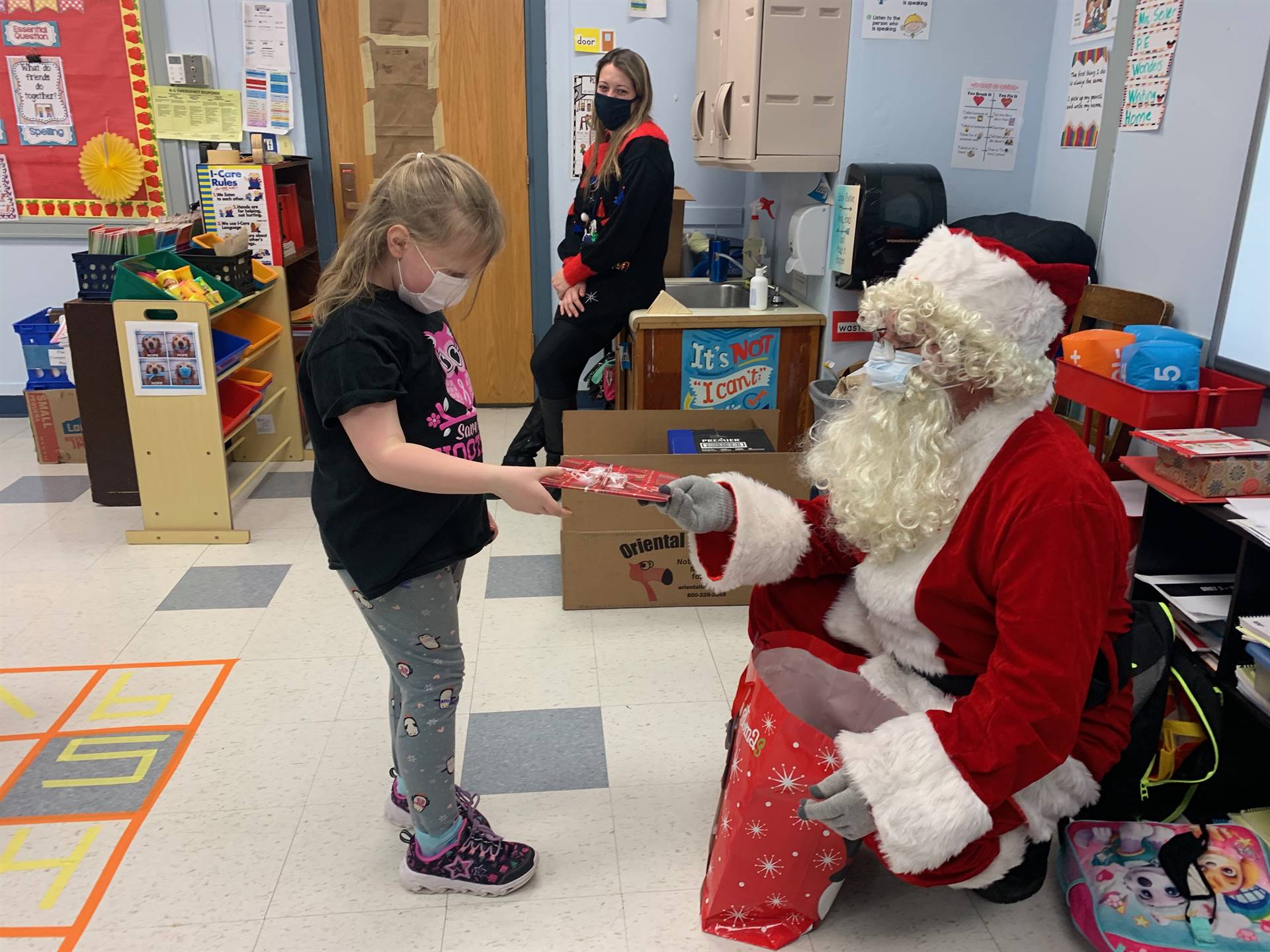 A student takes a gift from Santa.