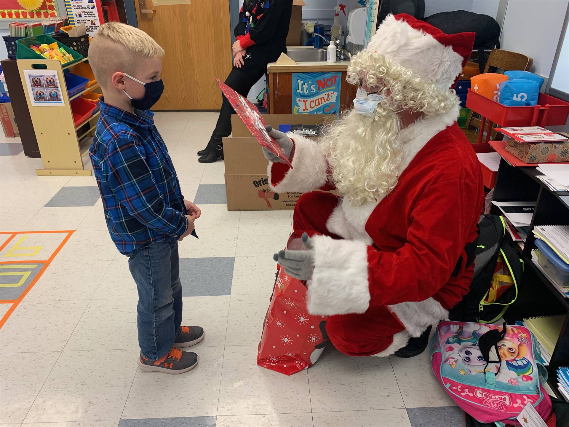 Santa shows a gift to a student.