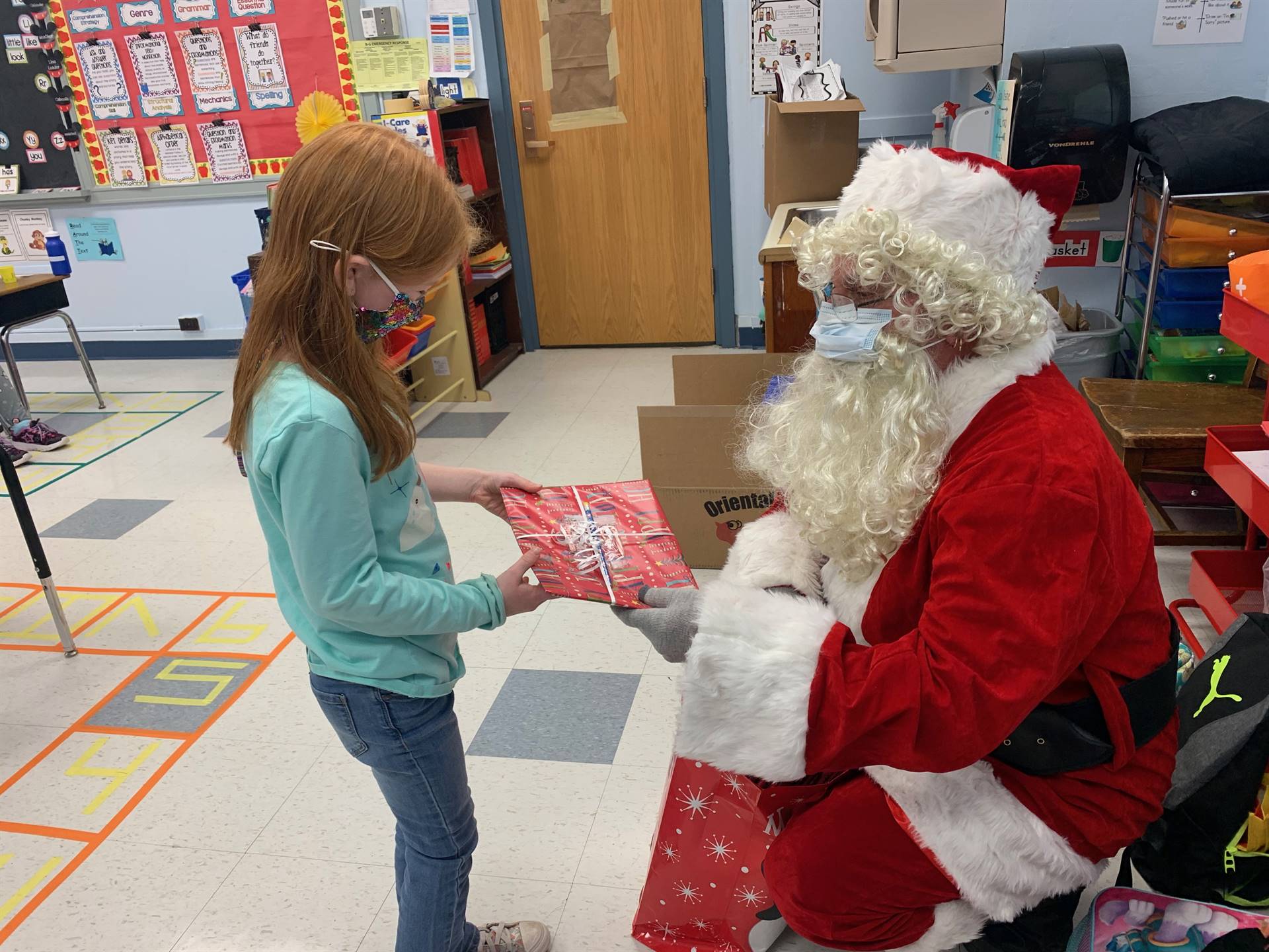 A  student accepts a gift from Santa.