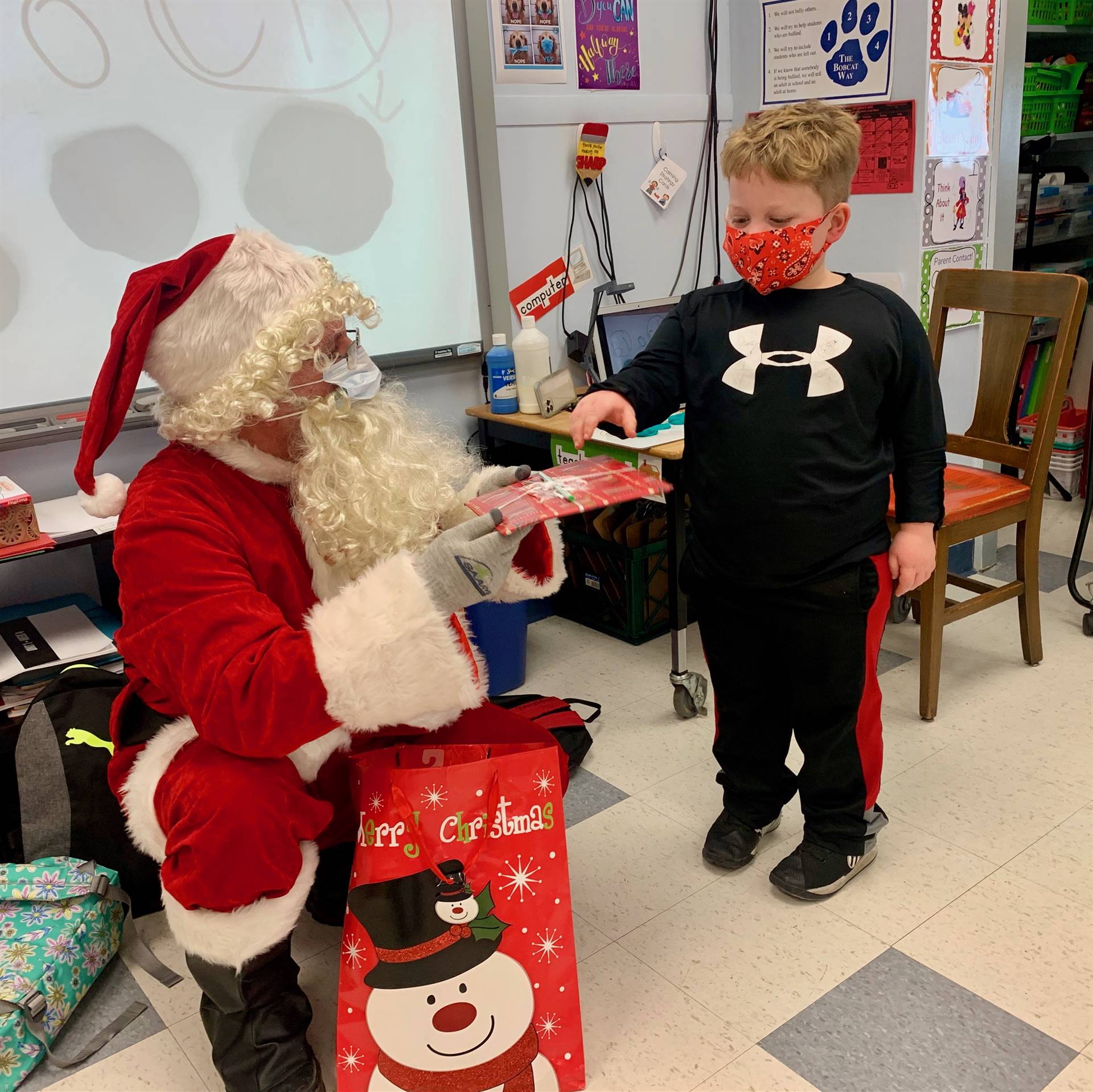 A student takes a gift from Santa.