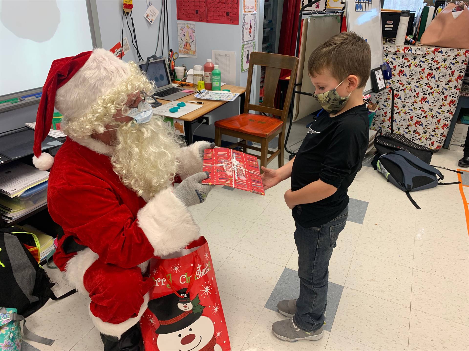 Santa gives a gift to a student.