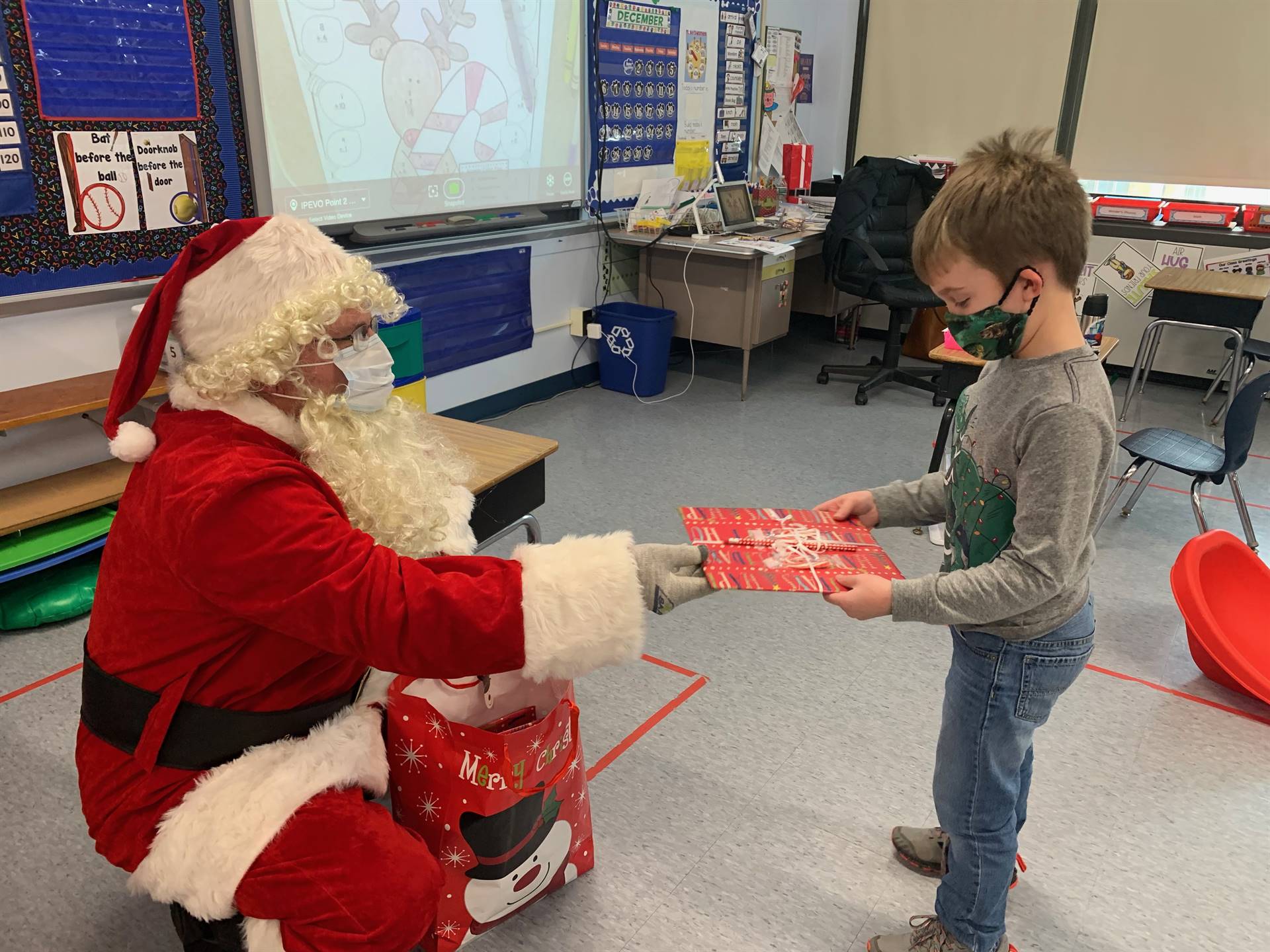 A student accepts a gift from Santa.