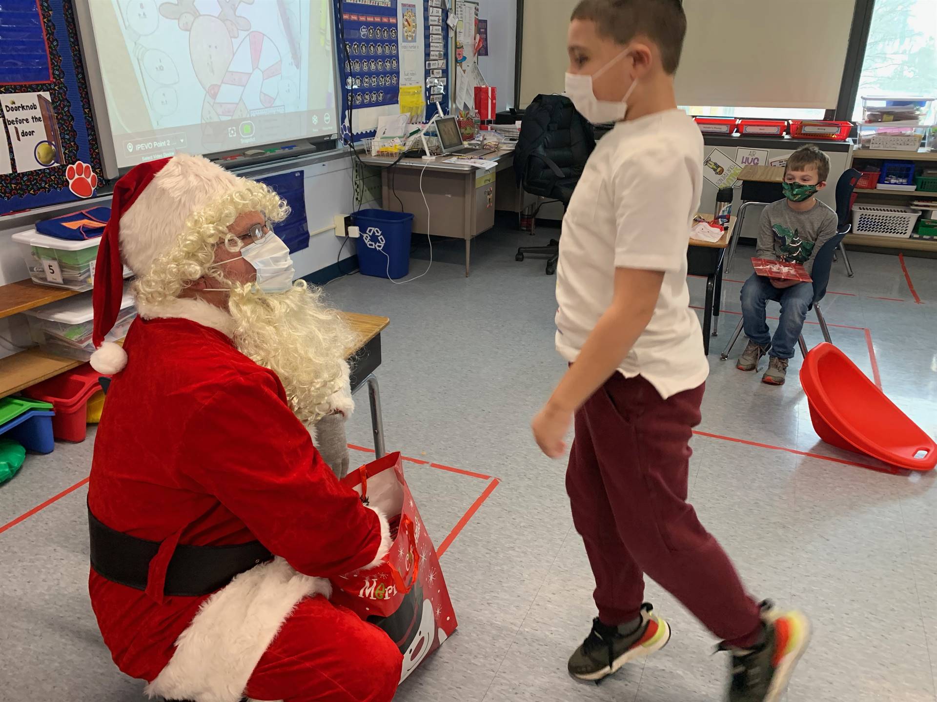 A students gives a happy hop as he approaches Santa.