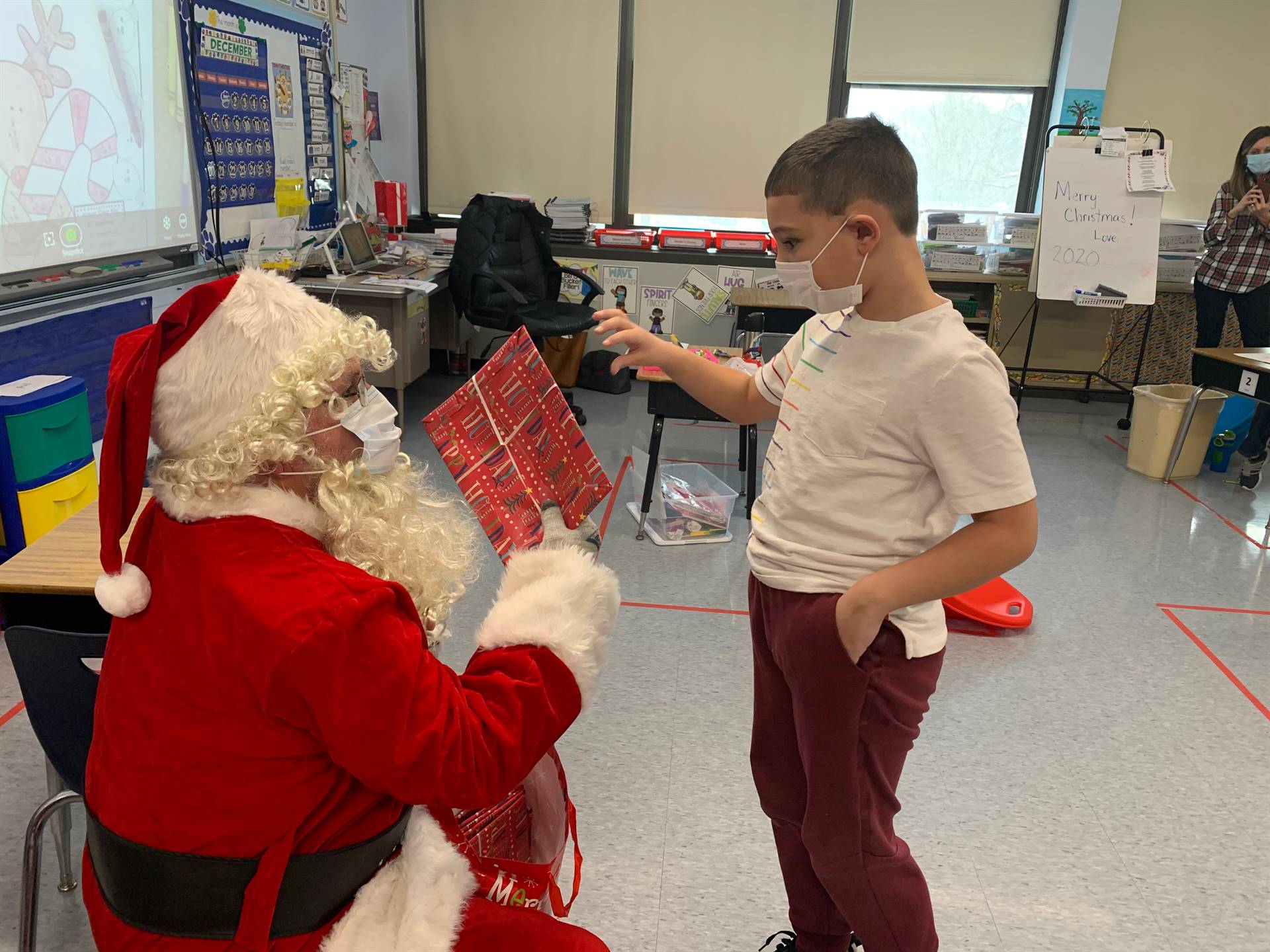 A student accepts a gift from Santa.