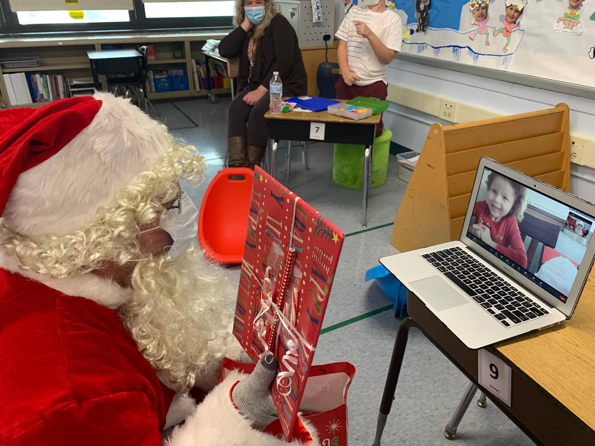 Santa presents a gift to a happy student on zoom!