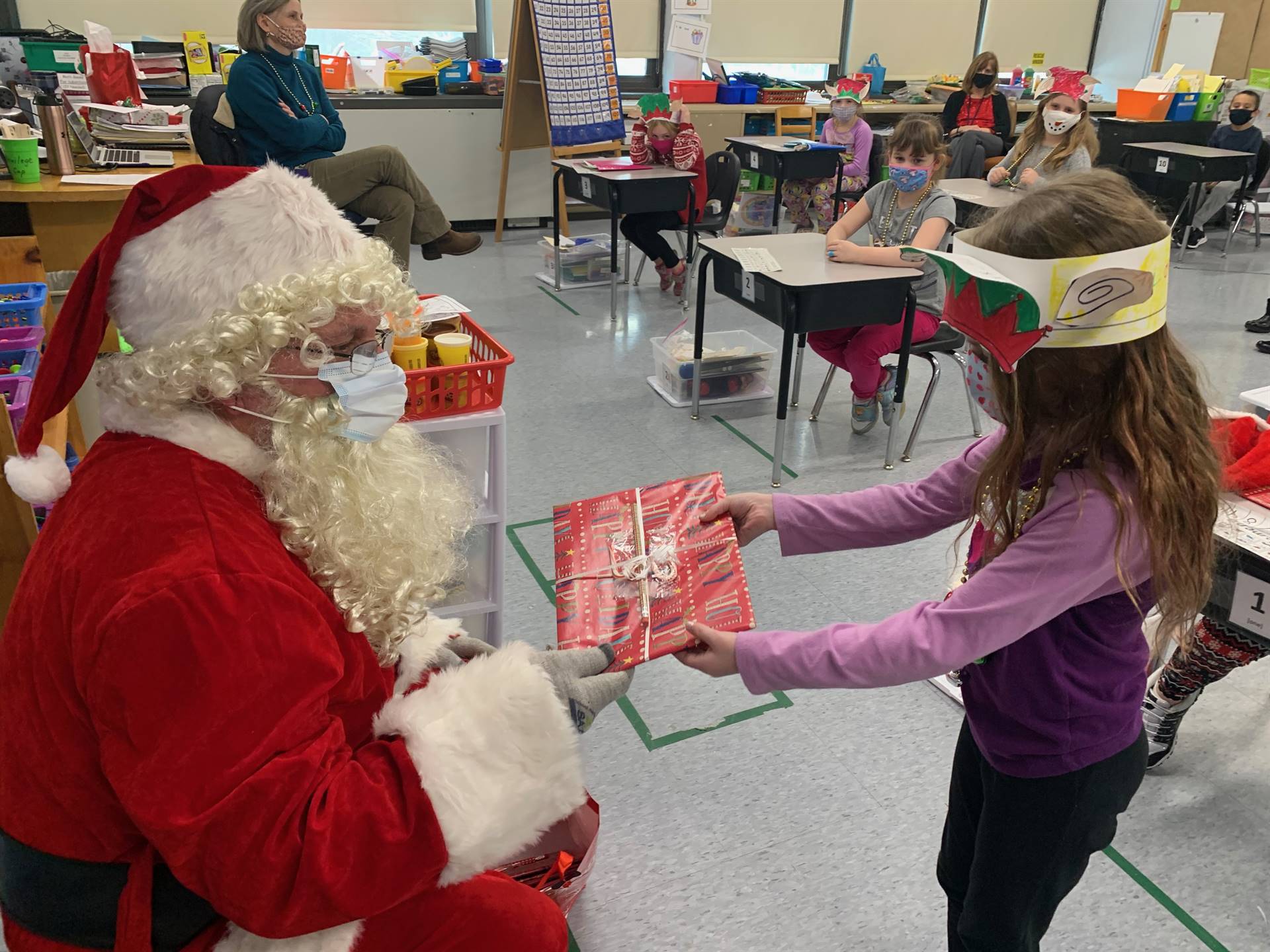 A student accepts a gift from Santa.