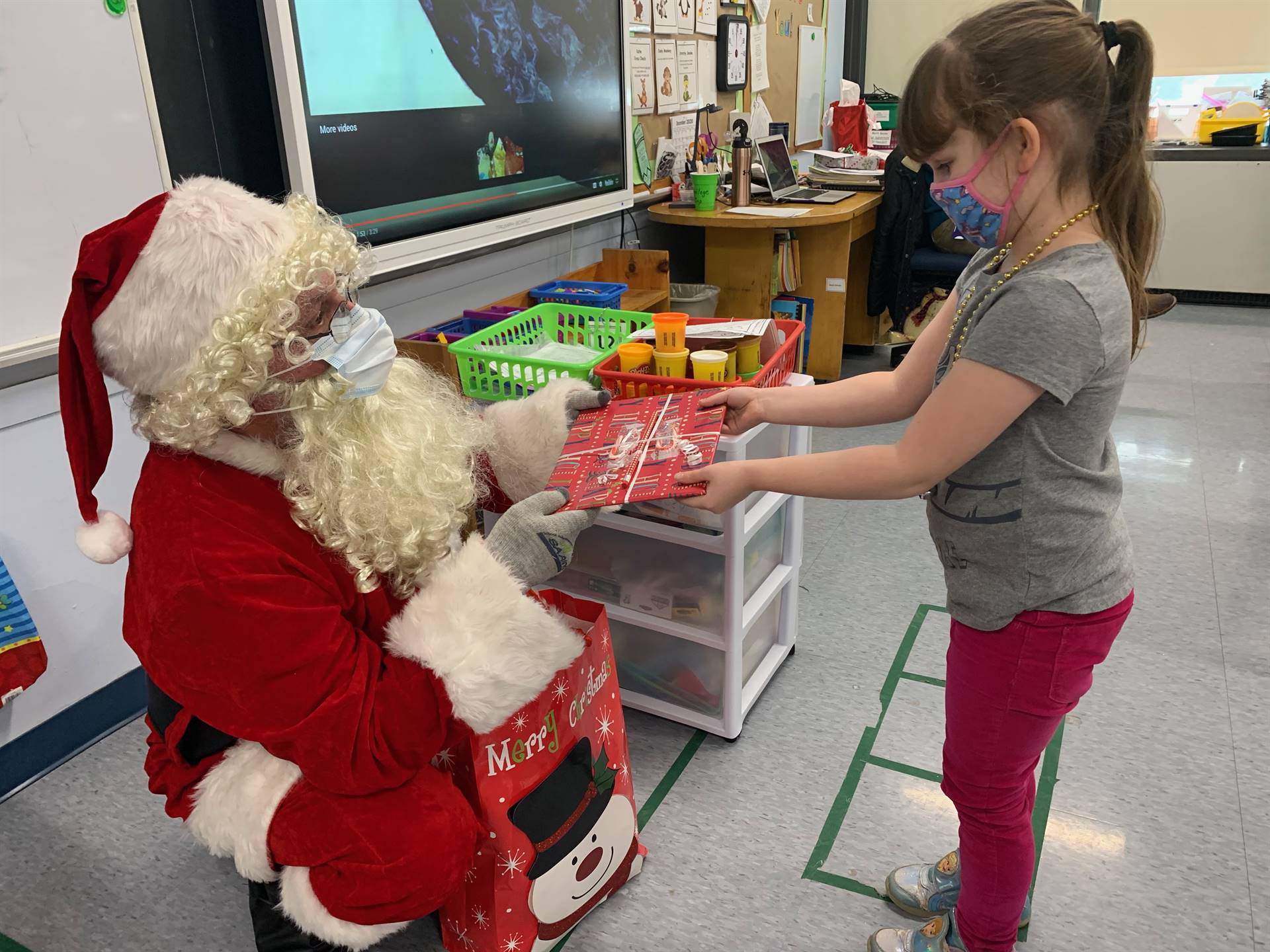 A student accepts a gift from Santa.