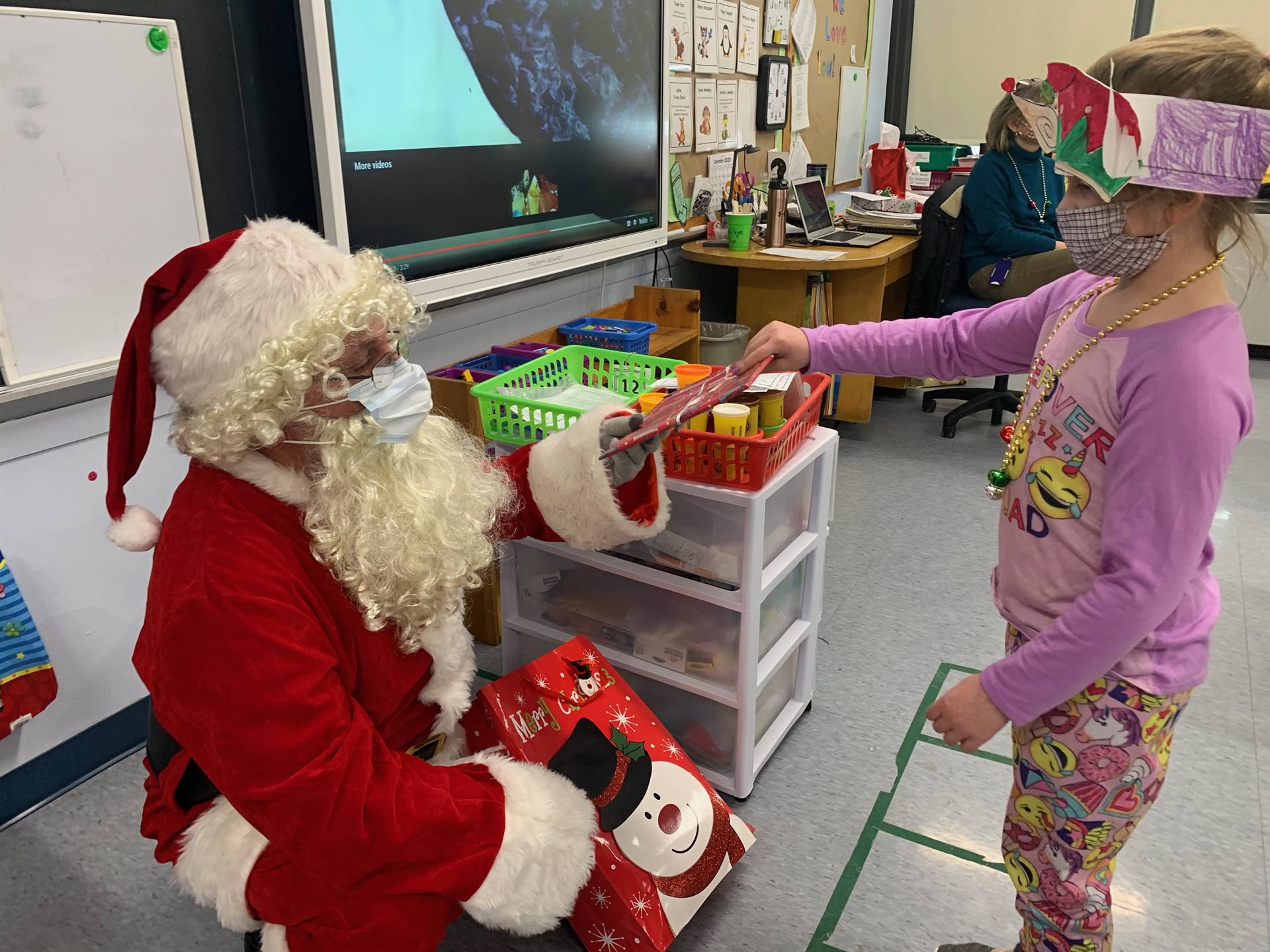 A student accepts a gift from Santa.