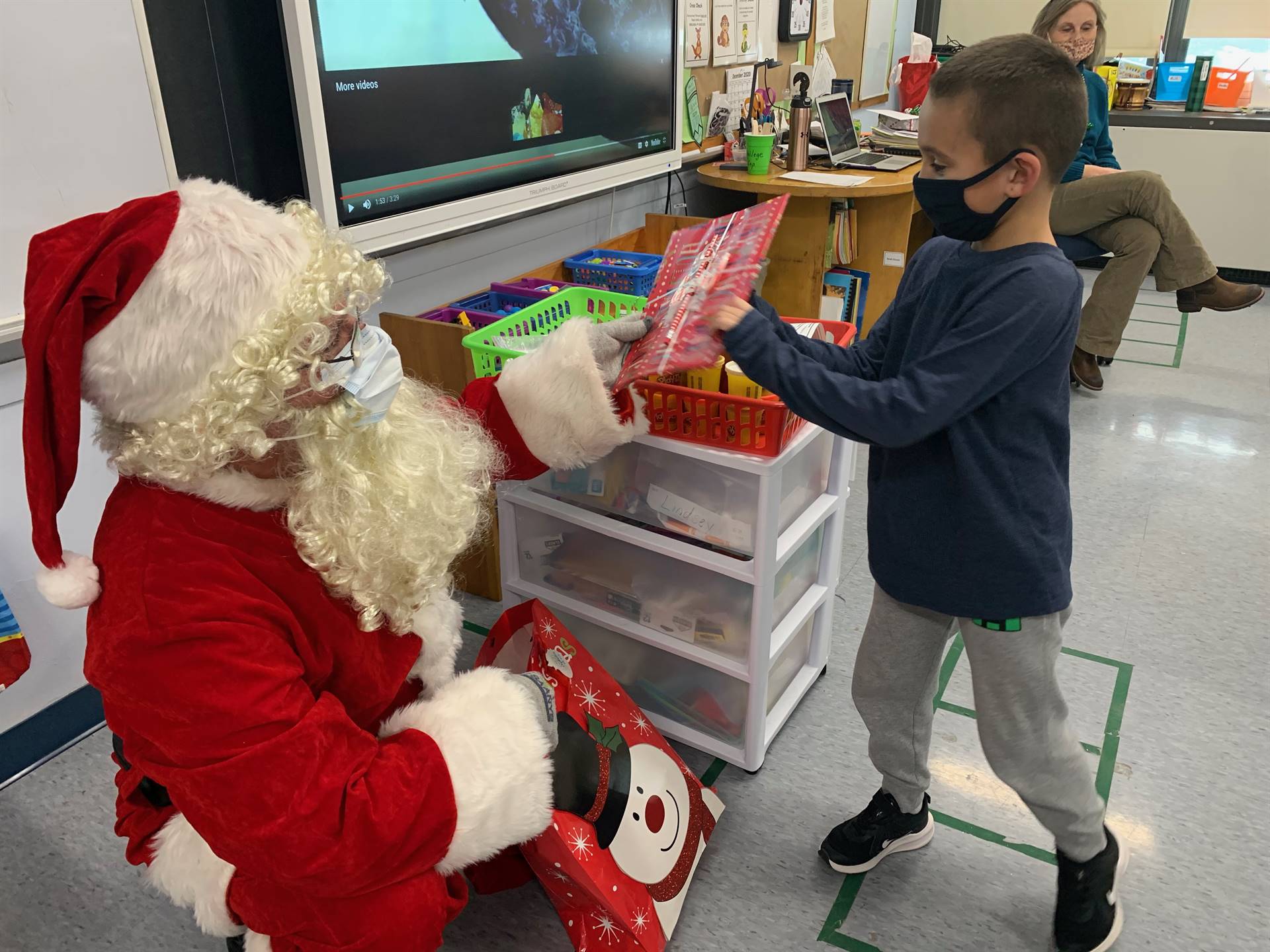 A student accepts a gift from Santa.