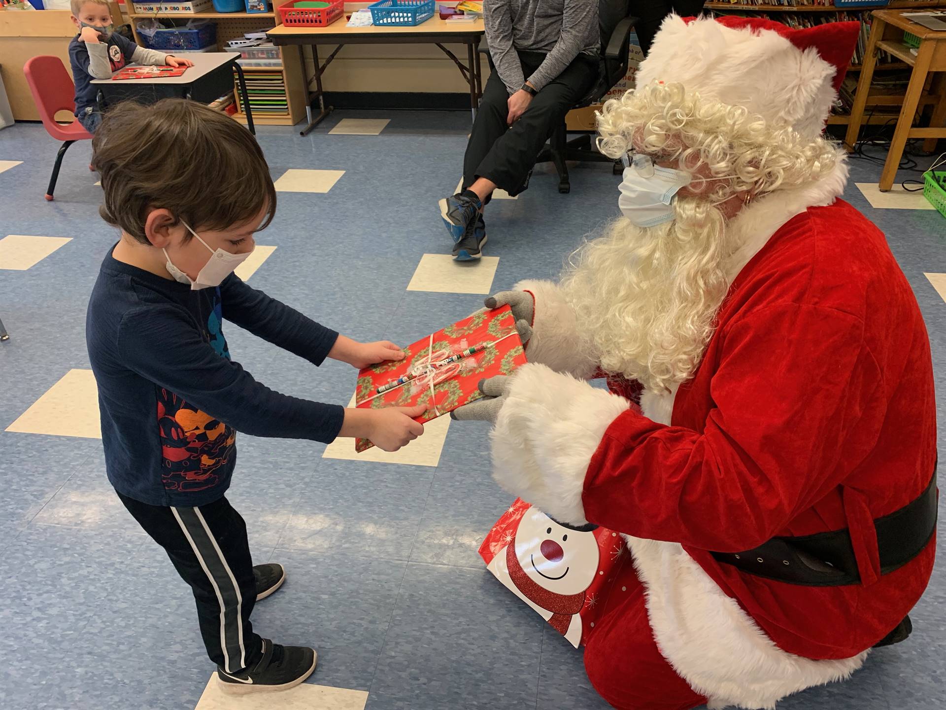 A student accepts a gift from Santa.