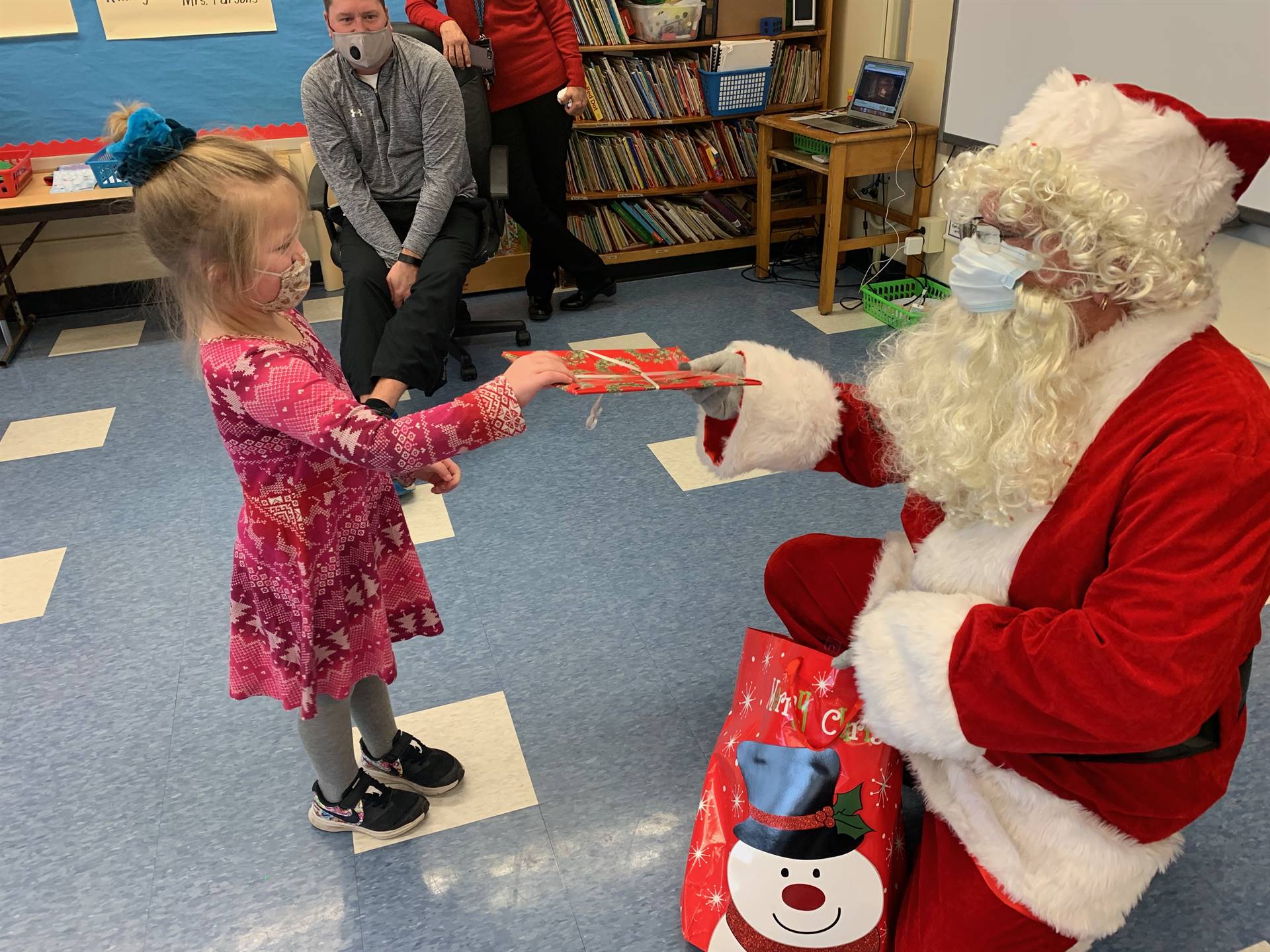 A student accepts a gift from Santa.