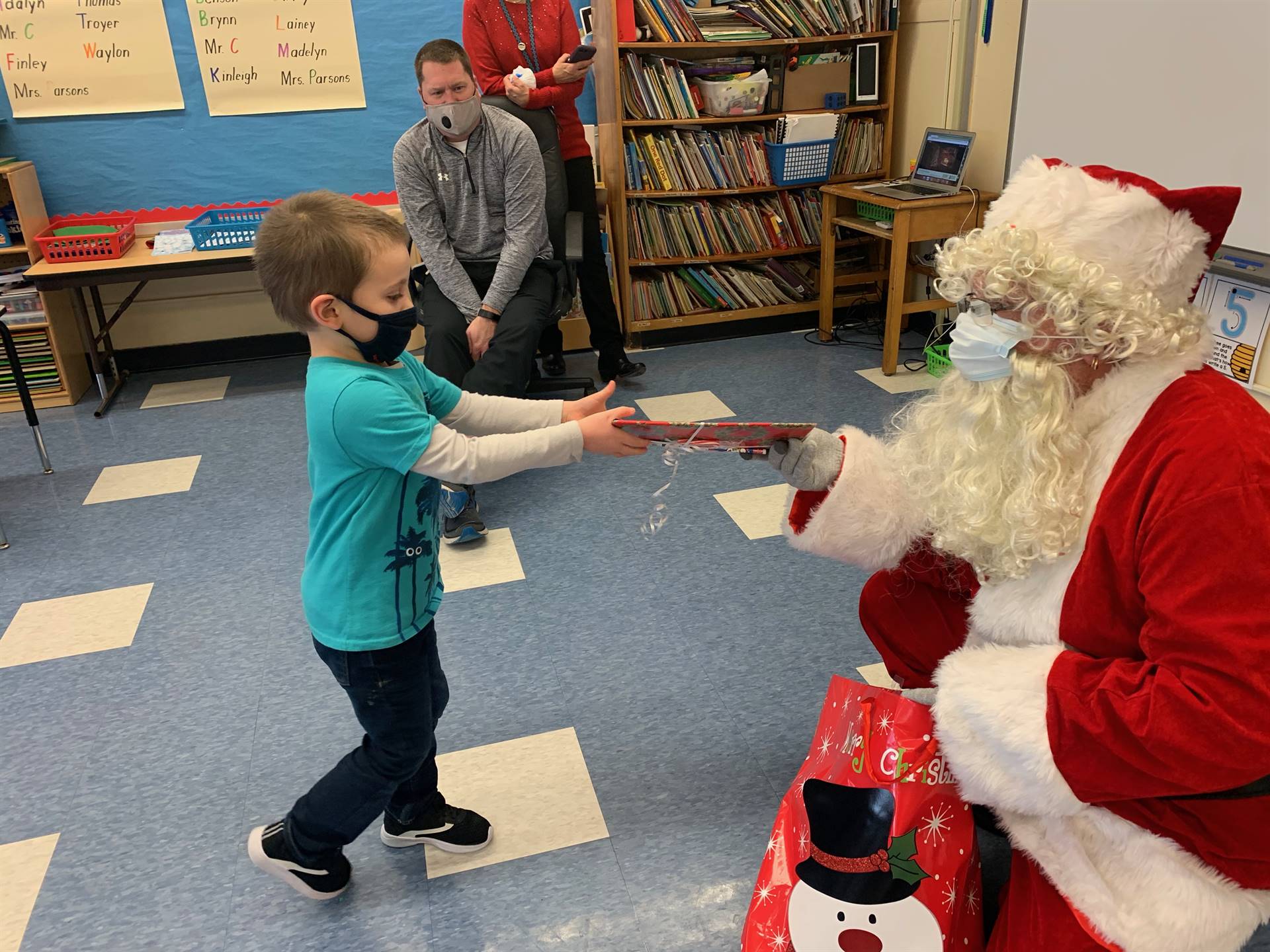 A student accepts a gift from Santa.