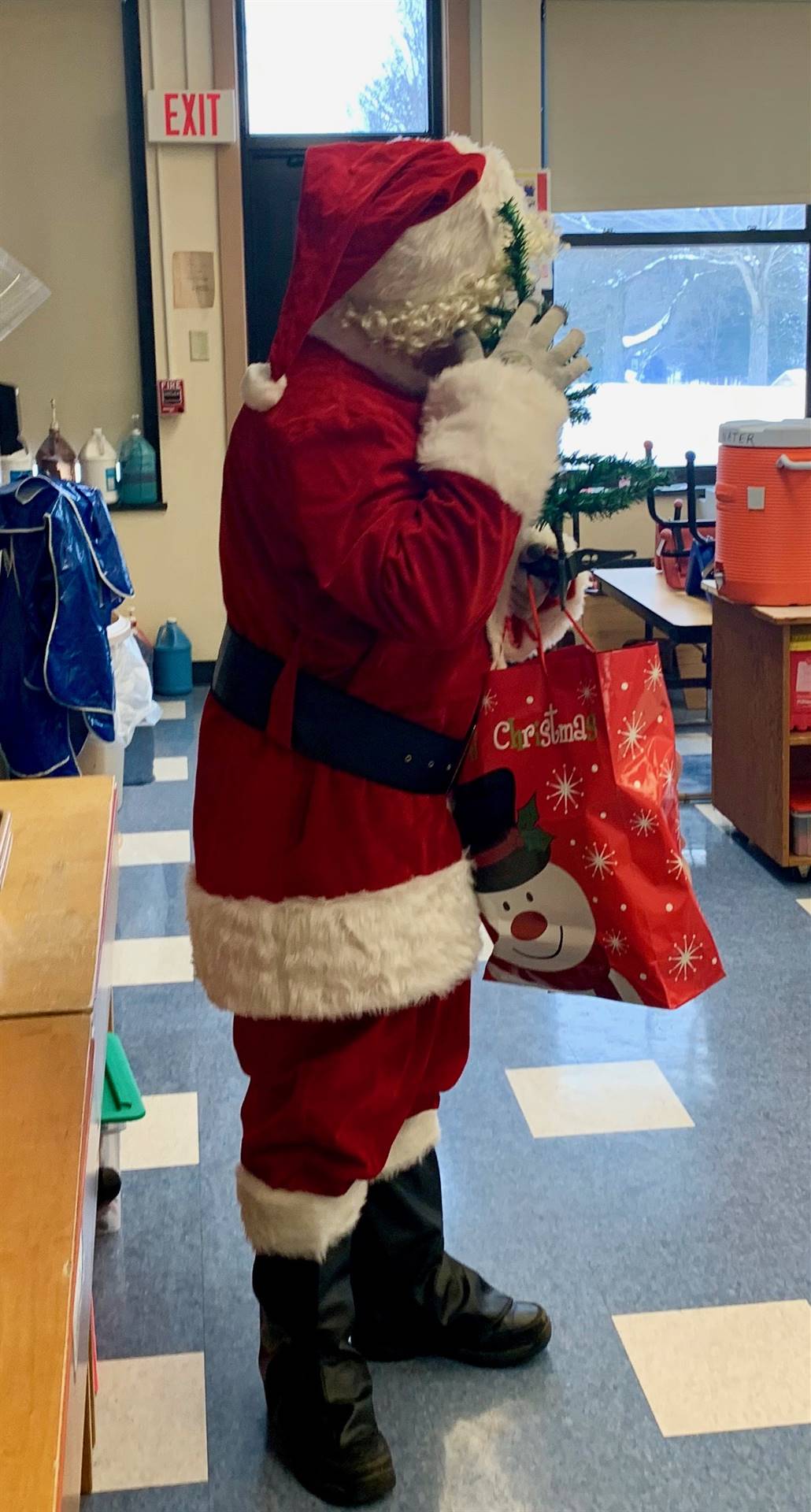 Santa hugs a Christmas tree. 