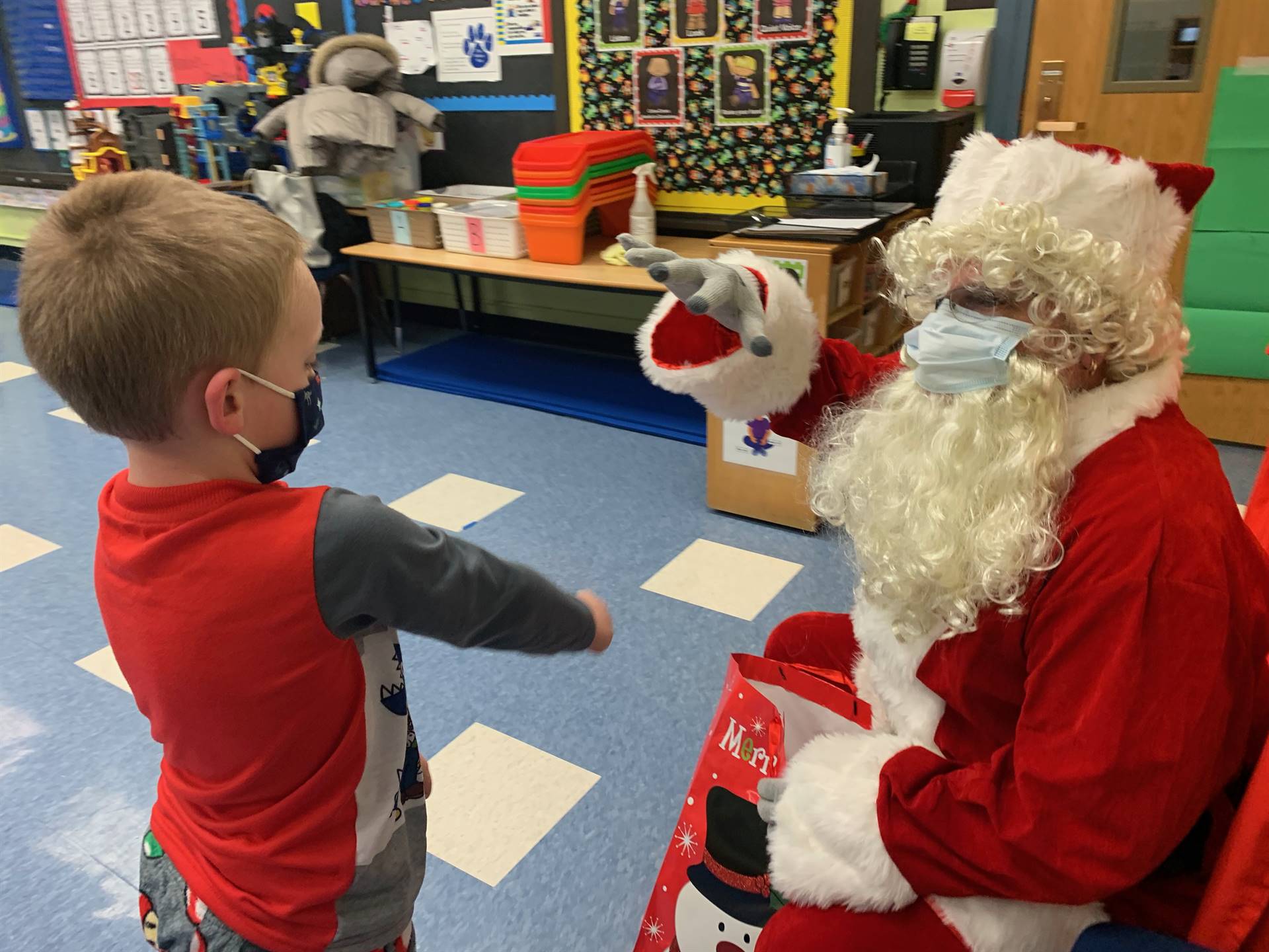 Santa gives a high 5 to a student. 