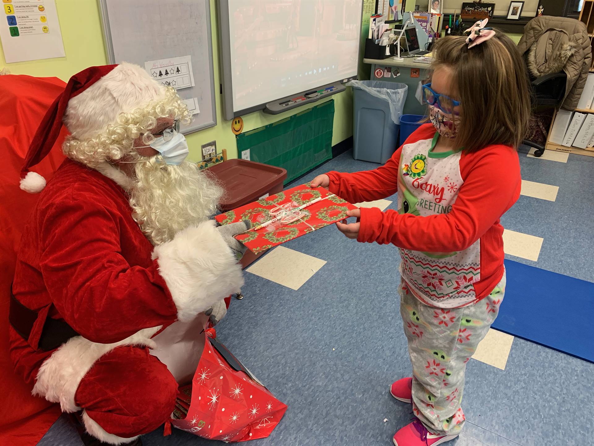 A student accepts a gift from Santa.