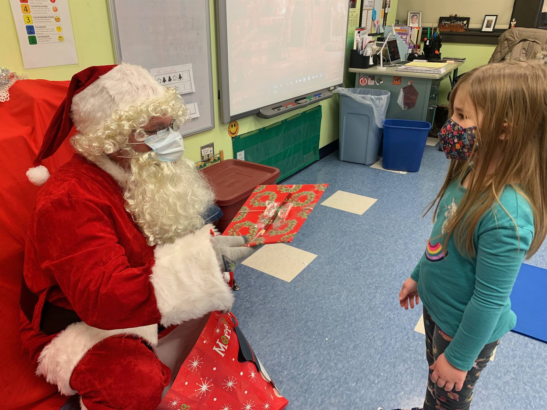 Santa asks a student if she is good.