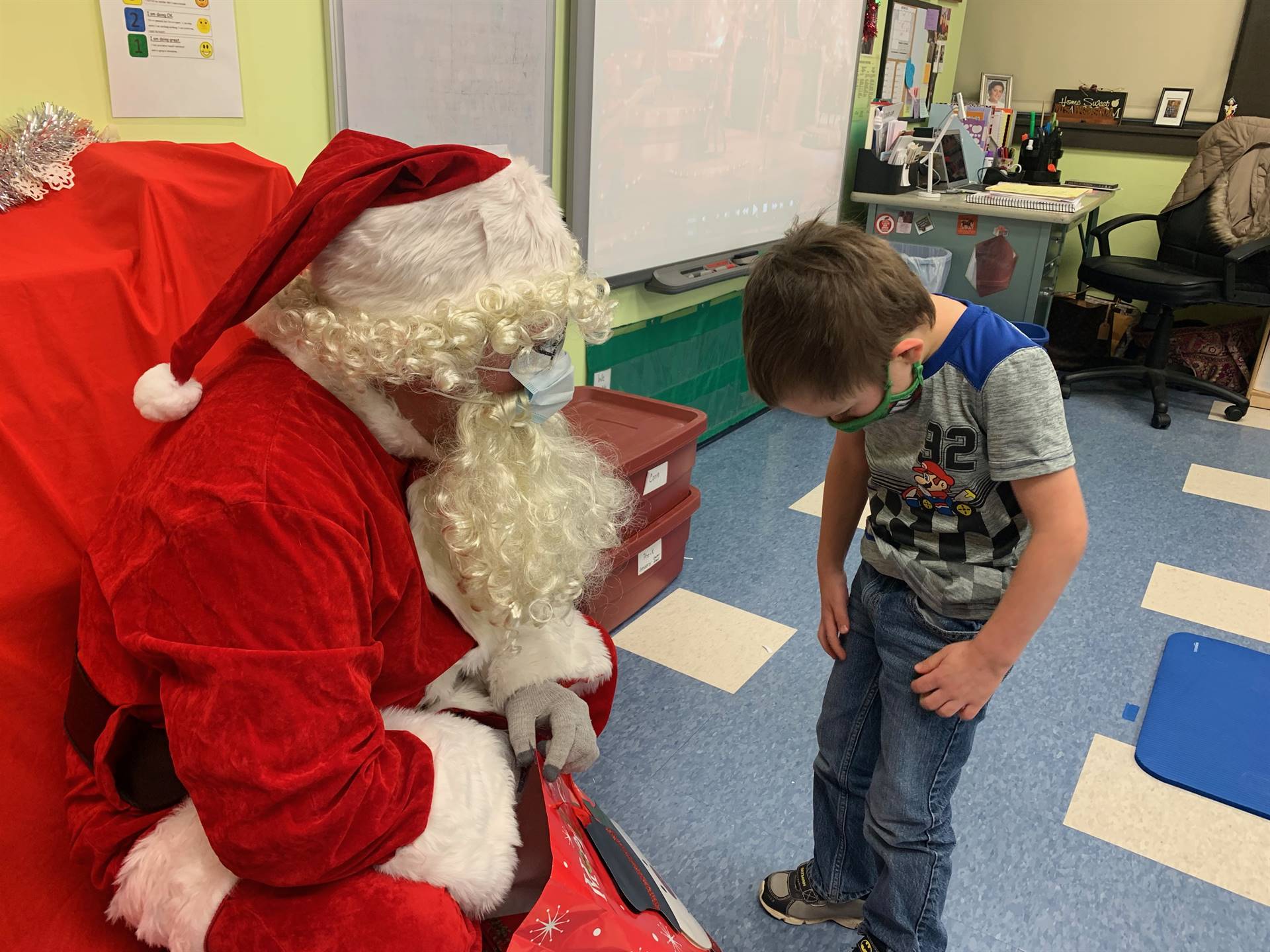 Santa points at a student's shirt. 