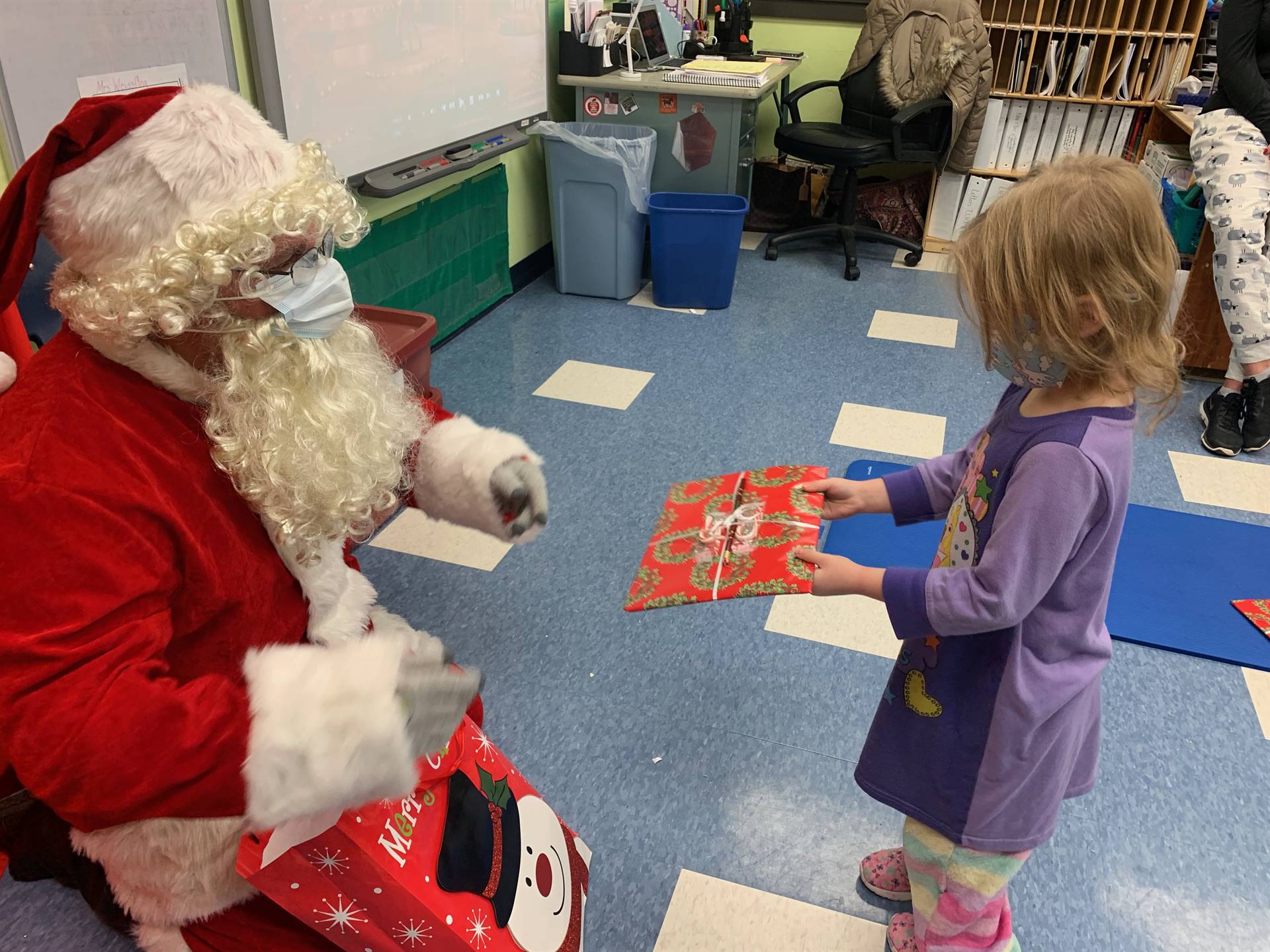 A student accepts a gift from Santa.