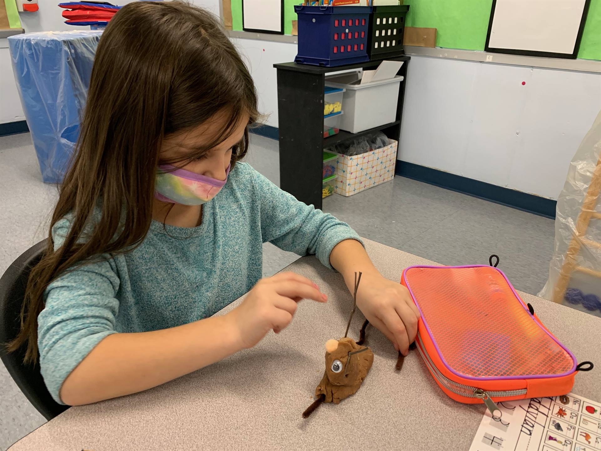 A student puts on finishing touches to a playdo reindeer.